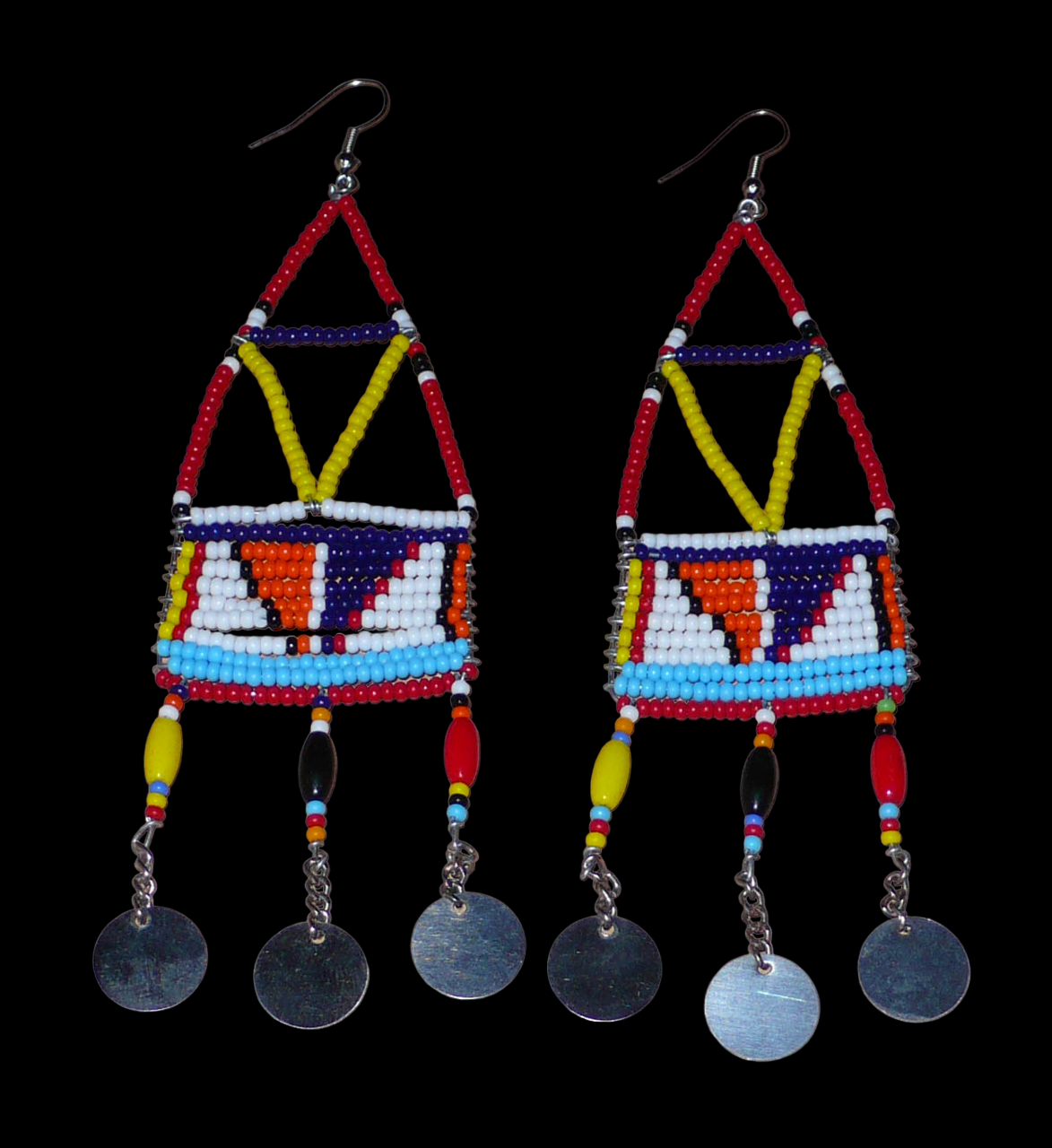 Longues boucles d'oreilles africaines à motifs géométriques Massai composées de perles de rocaille et de plastique rouges et multicolores, et de chaînettes décorées de perles et de disques métalliques. Elles mesurent 13 cm de long et 4 cm de large et se portent sur des oreilles percées.