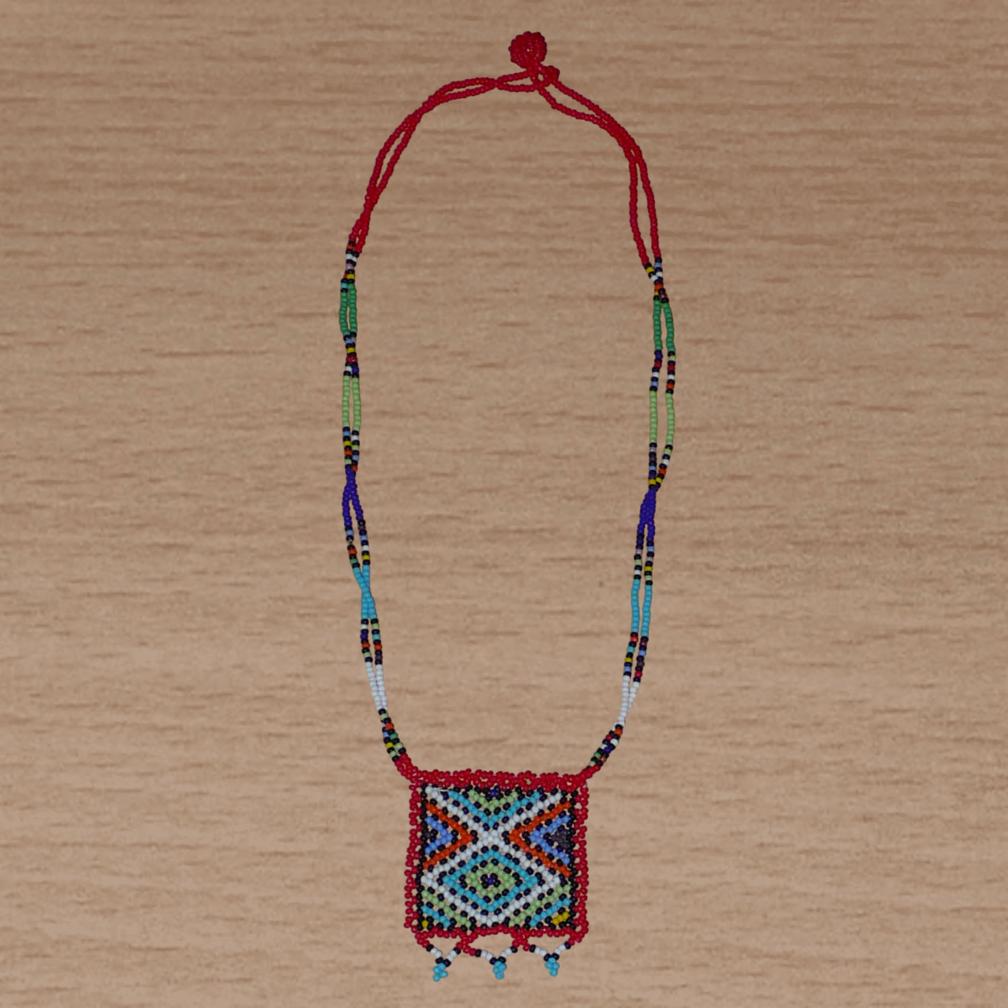 Collier africain traditionnel zoulou avec pendentif carré à motifs ethniques en perles de rocaille rouges et multicolores.