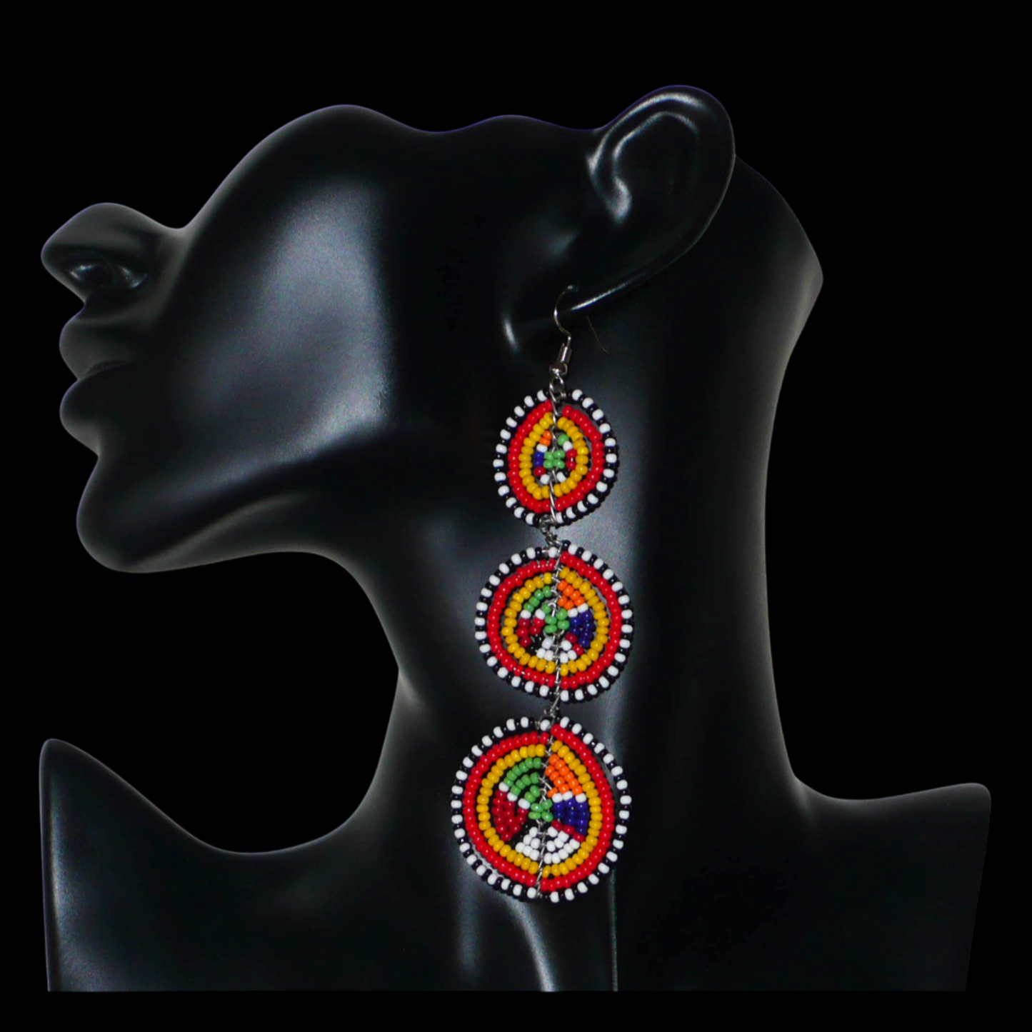 Affirmez votre style avec ces boucles d'oreilles africaines traditionnelles de confection artisanale Massai, évoquant le style afro chic des années 70. Elles se composent de perles de rocaille multicolores enfilées sur des fils de fer montés en forme de trois cercles superposés. Ces boucles d'oreilles mesurent 11 cm de long et 3.5 cm de large ; elles se portent avec des crochets en acier inoxydable sur des oreilles percées.