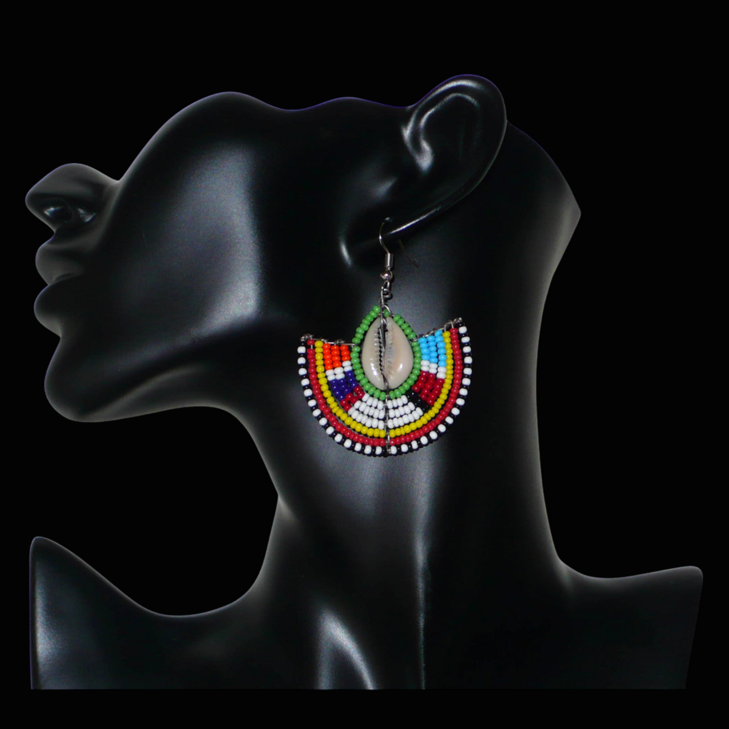 Ajoutez une touche afro chic à votre style avec cette jolie paire de boucles d'oreilles africaines issues de l'artisanat traditionnel Massai. Ces boucles d'oreilles aux accents exotiques se composent de perles de rocaille vertes et multicolores et de coquillages cauris. De taille moyenne, elles mesurent 6 cm de long et 4.5 cm de large, et se portent avec des crochets en acier inoxydable sur des oreilles percées.
