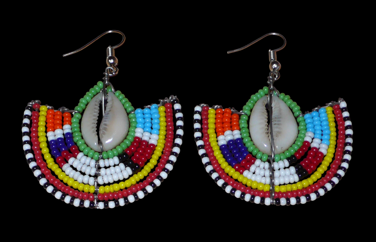 Ajoutez une touche afro chic à votre style avec cette jolie paire de boucles d'oreilles africaines issues de l'artisanat traditionnel Massai. Ces boucles d'oreilles aux accents exotiques se composent de perles de rocaille vertes et multicolores et de coquillages cauris. De taille moyenne, elles mesurent 6 cm de long et 4.5 cm de large, et se portent avec des crochets en acier inoxydable sur des oreilles percées.