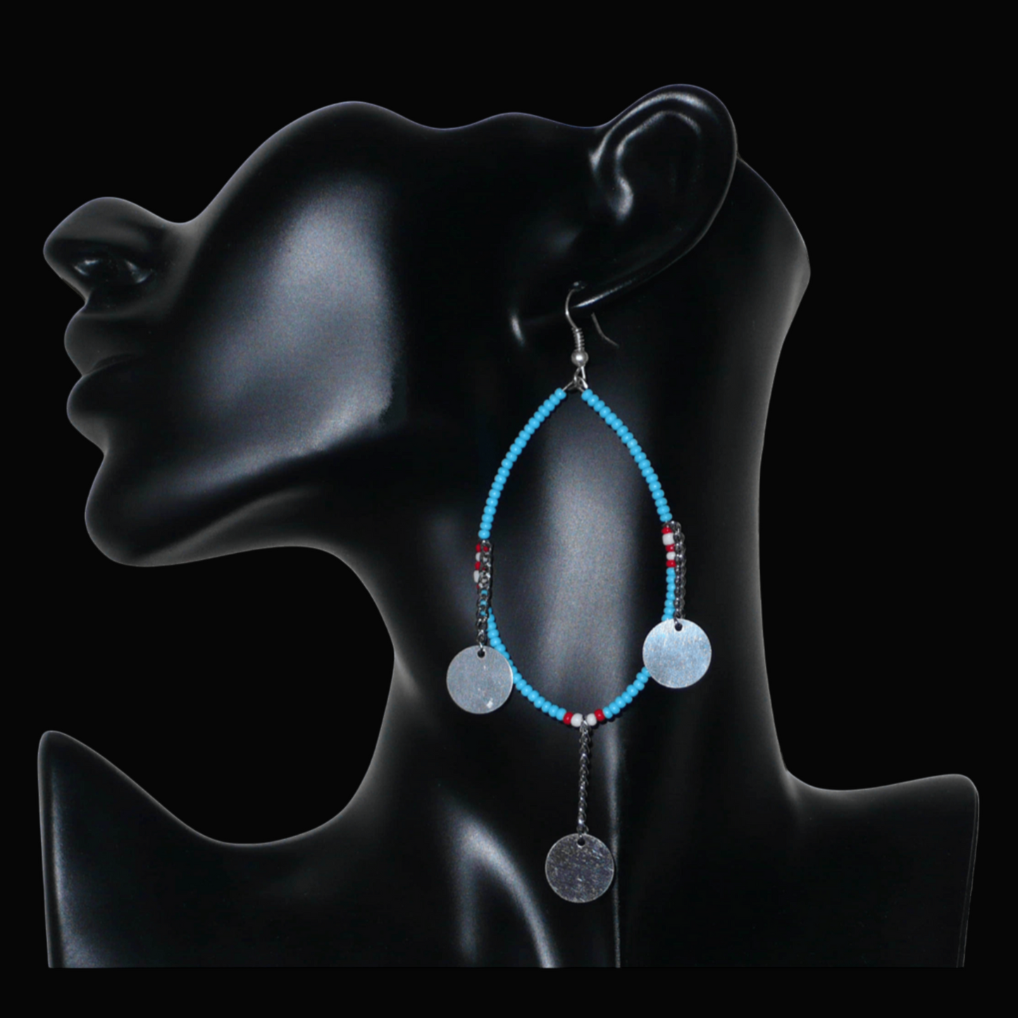 Longues boucles d'oreilles africaines Massai composées de perles bleu turquoise, blanches et rouges glissées sur un brin de fil de fer monté en forme de goutte, et de chaînettes ornées de pastilles en métal. Ces boucles d'oreilles ethniques chic mesurent 11,5 cm de long et 4 cm de large, et se portent avec des crochets en acier inoxydable sur des oreilles percées.