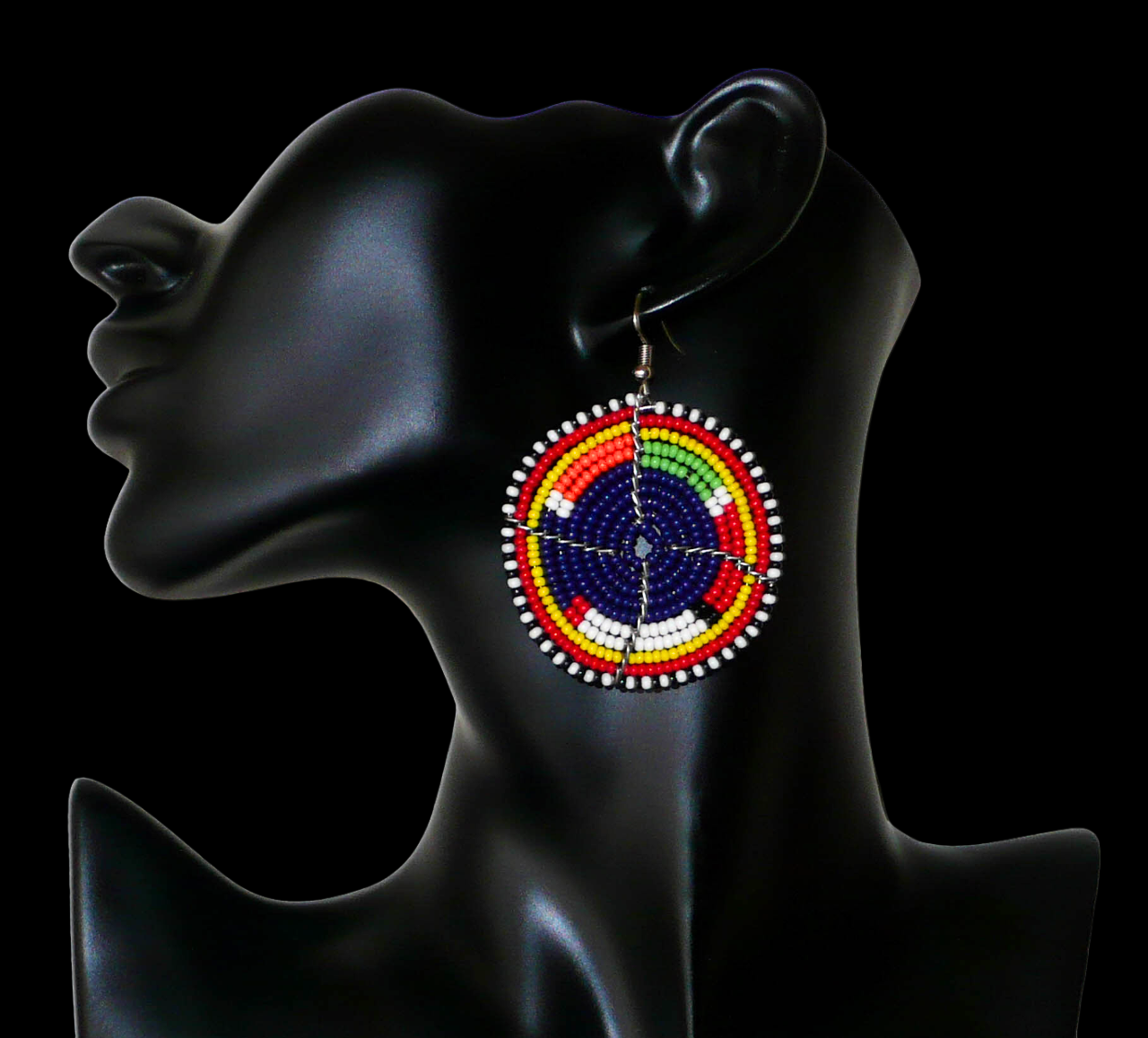 Boucles d'oreilles africaines rondes à motifs ethniques Massai en perles de rocaille bleu foncé et multicolores. Elles mesurent 7 cm de long et 5 cm de large et se portent sur des oreilles percées.
