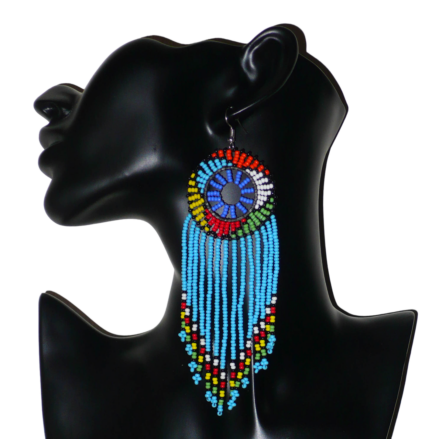 Longues boucles d'oreilles sud-africaines traditionnelles à franges et motifs zoulous composées de perles de rocaille bleu ciel et multicolores. Elles mesurent 14,5 cm de long et 4,5 cm de large, et se portent avec des crochets en acier inoxydable sur des oreilles percées.