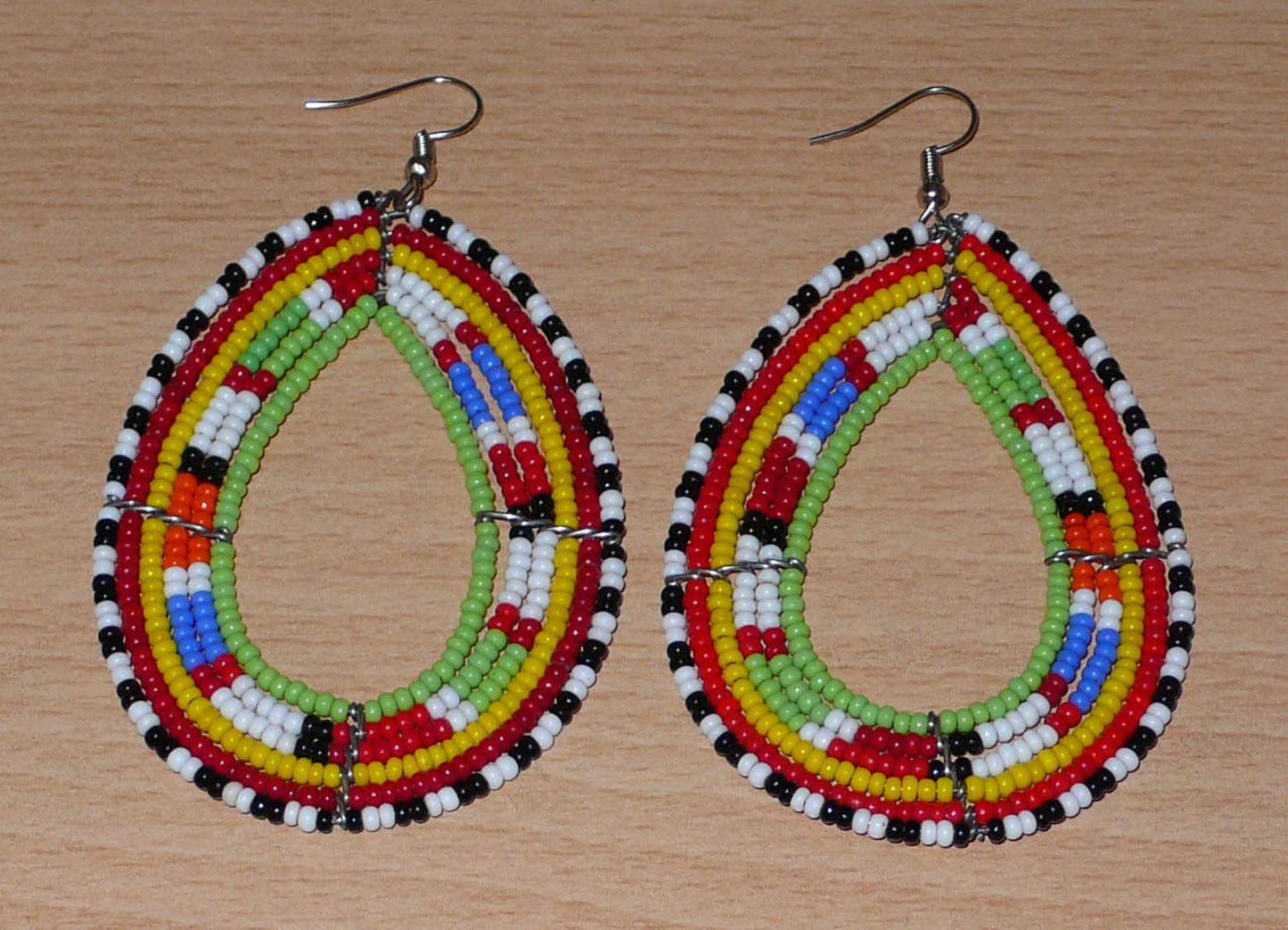 Longues boucles d'oreilles africaines Massai en perles de rocaille multicolores glissées sur six rangées de fils de fer montées en forme de gouttes. Elles mesurent 8,5 cm de long et 5 cm de large.