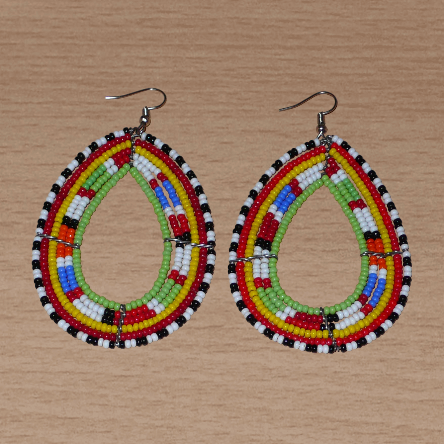Longues boucles d'oreilles africaines Massai en perles de rocaille multicolores glissées sur six rangées de fils de fer montées en forme de gouttes. Elles mesurent 8,5 cm de long et 5 cm de large.