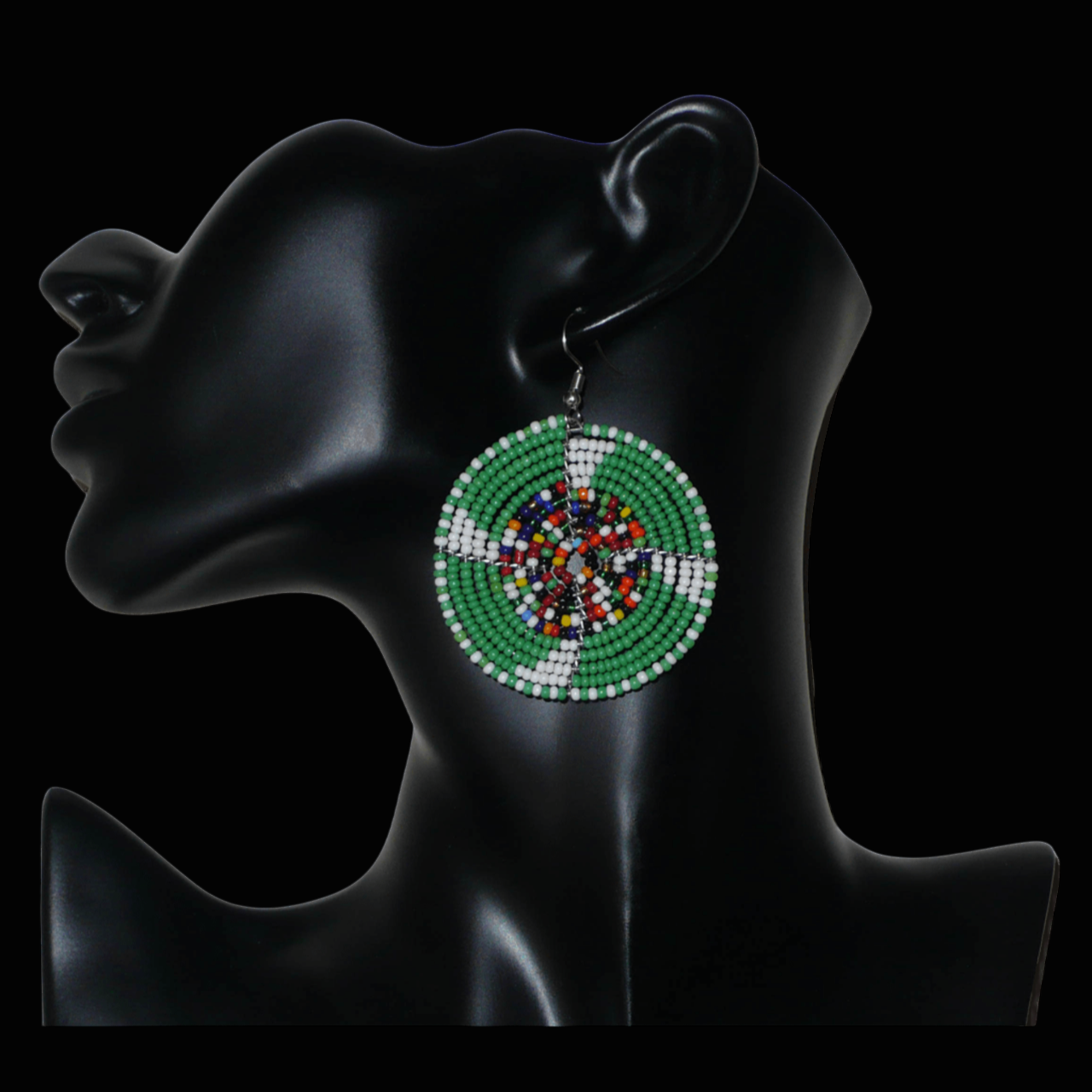 Ajoutez une touche ethnique afro bohème à votre look avec ces boucles d'oreilles africaines rondes confectionnées à la main dans la tradition artisanale Massai : elles se composent de perles de rocaille principalement vertes, puis blanches et multicolores glissées sur des structures circulaires en fils de fer.
Cette paire de boucles d'oreilles mesure 6.5 cm de long et 4.5 cm de large, et se porte avec des crochets en acier inoxydable sur des oreilles percées.