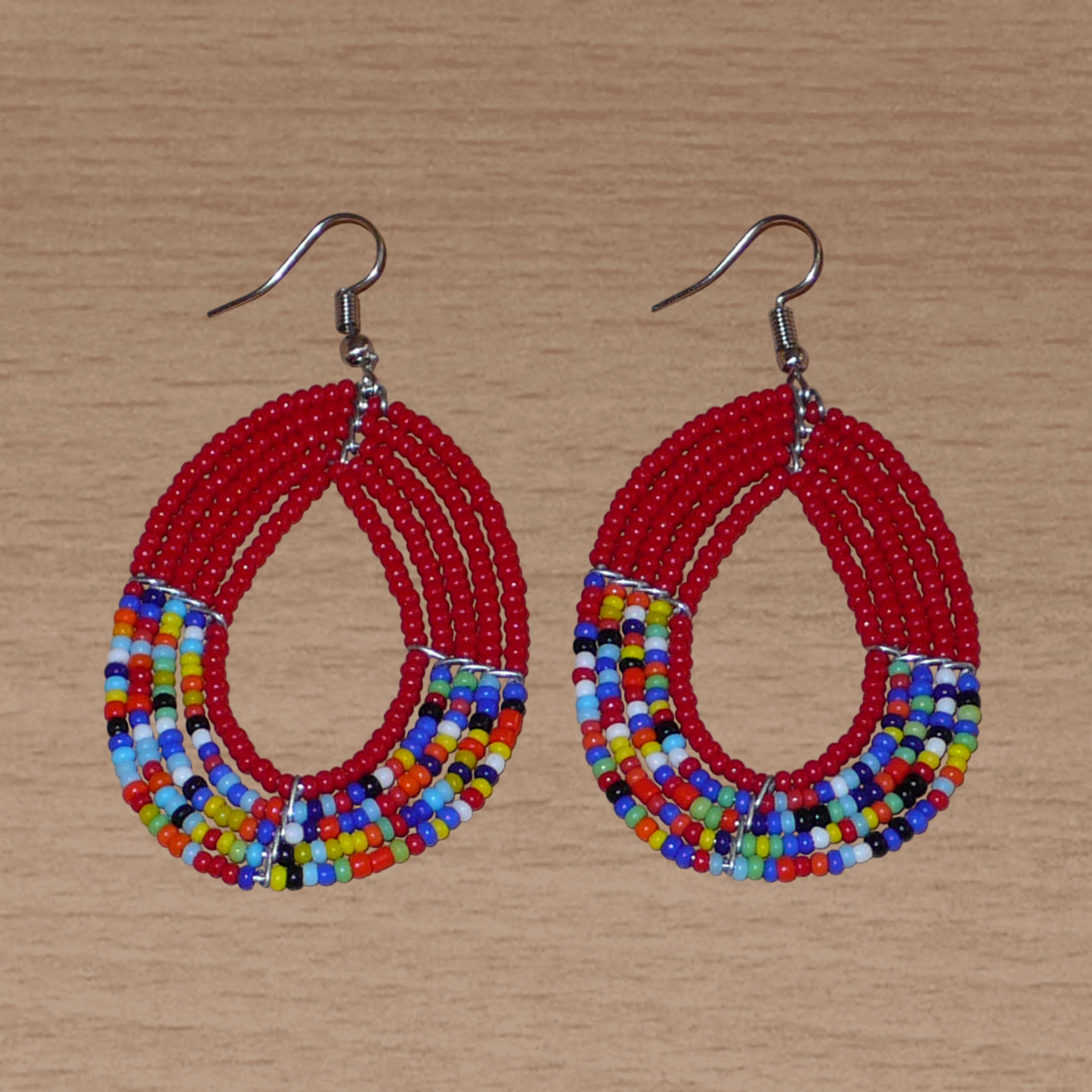 Boucles d'oreilles rouges et multicolores en forme de gouttes composées de perles de rocaille.