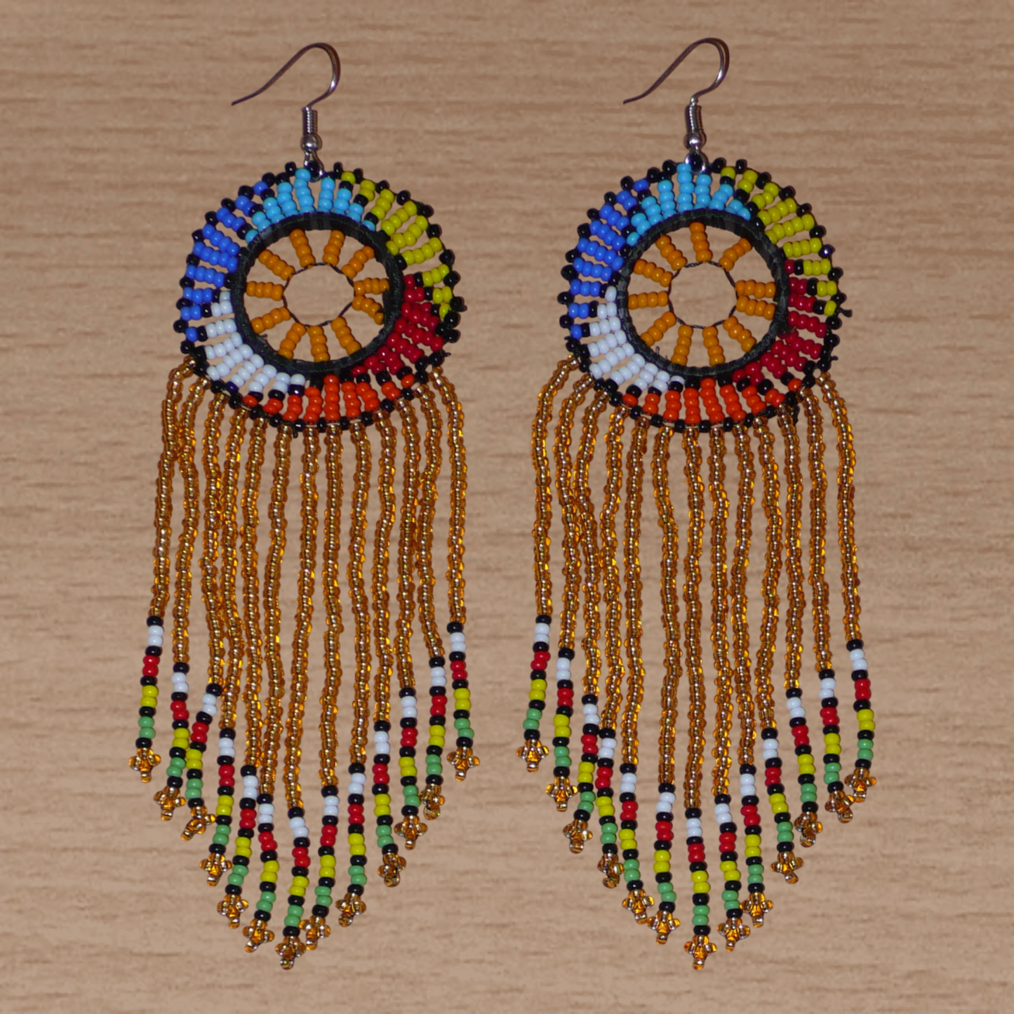 Boucles d'oreilles sud-africaines à franges et motifs traditionnels composées de perles de rocaille translucides dorées et multicolores. Elles mesurent 14,5 cm de long et 4,5 cm de large.