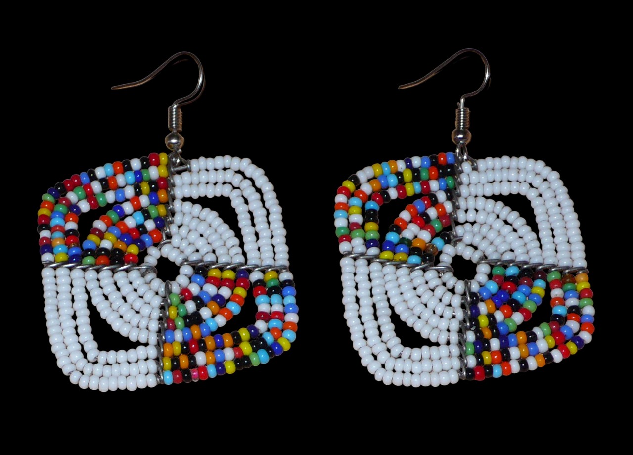 Boucles d'oreilles africaines Massai de confection artisanale kenyane composées de perles de rocaille blanches et d'un mélange de perles multicolores. Ces boucles d'oreilles aux accents exotiques mesurent 6.5 cm de long et 4.5 cm de large, et se portent avec des crochets en acier inoxydable sur des oreilles percées.