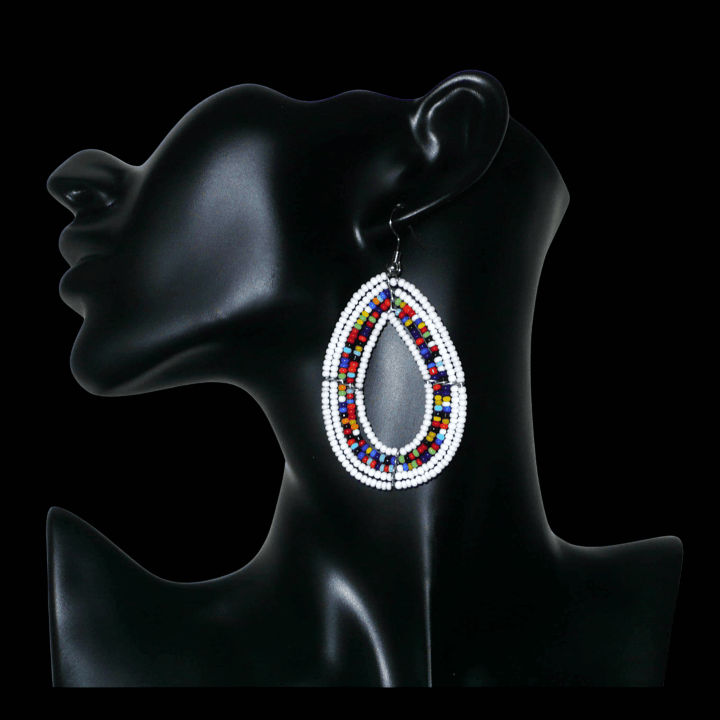 Boucles d'oreilles bohème blanches et multicolores en forme de gouttes faites de perles de rocaille. Elles mesurent 7,5 cm de long et 4 cm de large et se portent sur des oreilles percées.