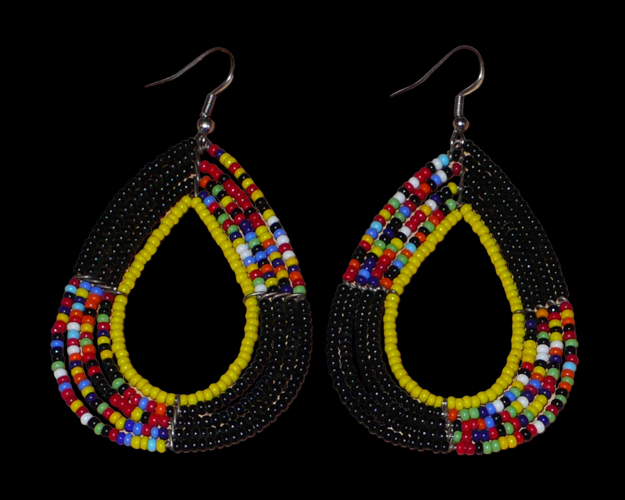 Longues boucles d'oreilles ethniques fabriquée au Kenya faites de perles de rocaille noires, jaunes et multicolores montées en forme de gouttes. Elles mesurent 8,5 cm de long et 4,5 cm de large et se portent avec des crochets en acier inoxydable sur des oreilles percées.