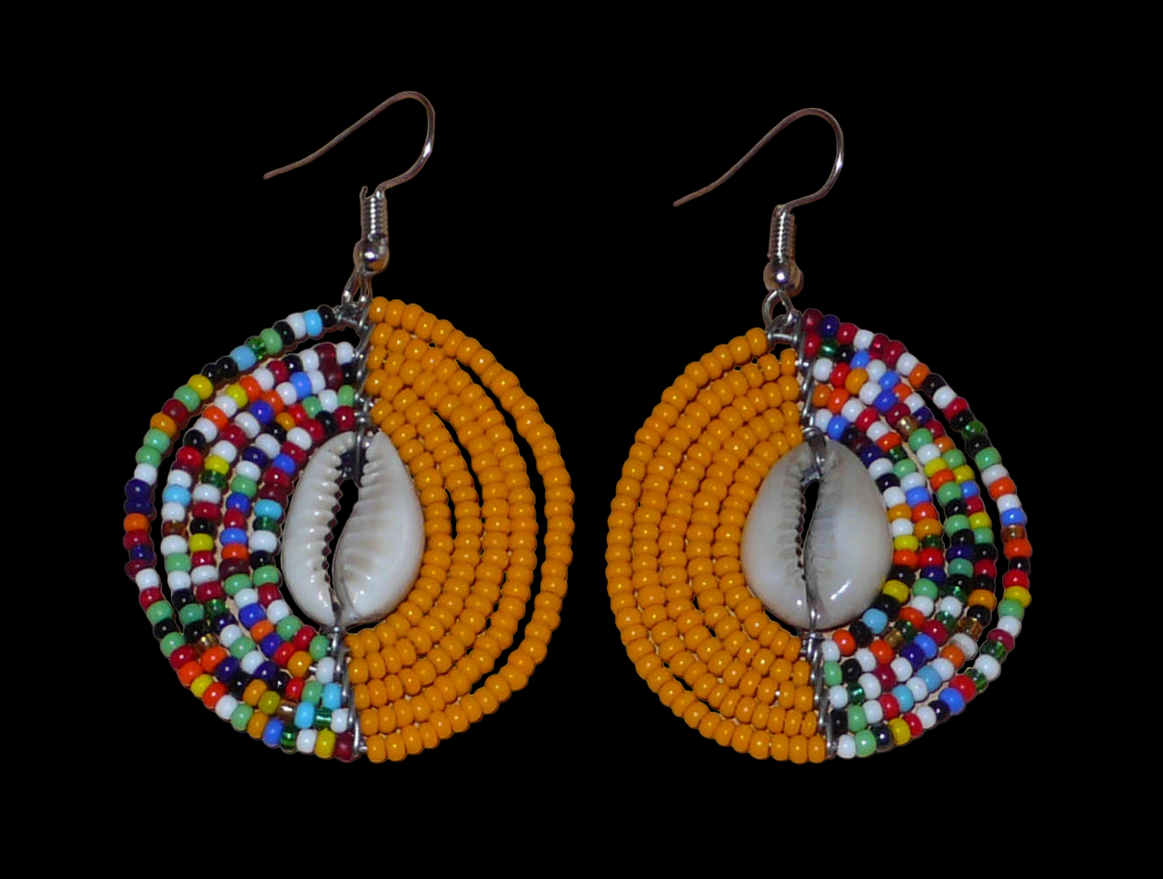 Boucles d'oreilles ethniques orange et multicolores fabriquées au Kenya composées de perles de rocaille et de coquillages cauris. De taille moyenne, elles mesurent 6 cm de long et 3,5 cm de large et se portent sur des oreilles percées.