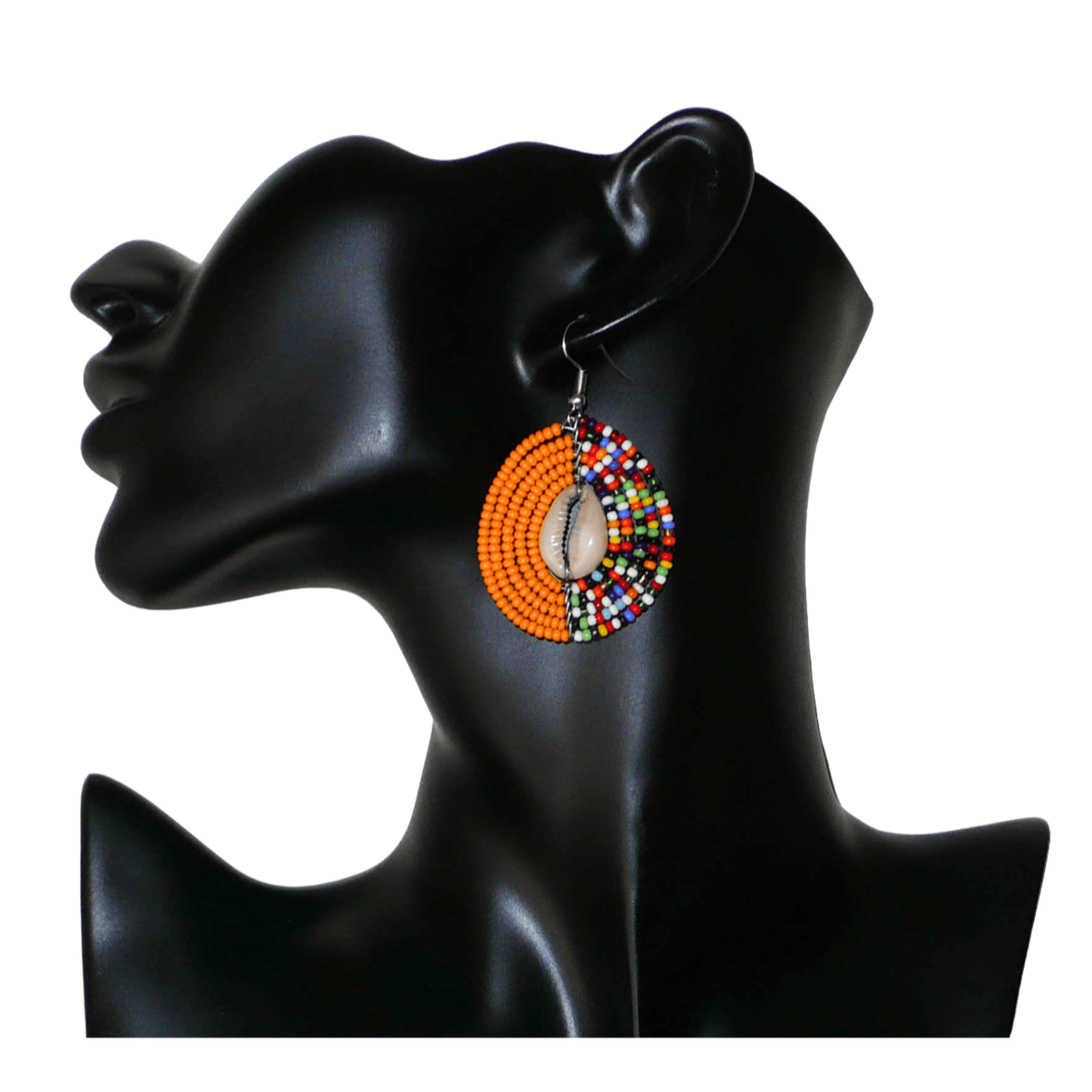 Boucles d'oreilles ethniques orange et multicolores fabriquées au Kenya composées de perles de rocaille et de coquillages cauris. De taille moyenne, elles mesurent 6 cm de long et 3,5 cm de large et se portent sur des oreilles percées.