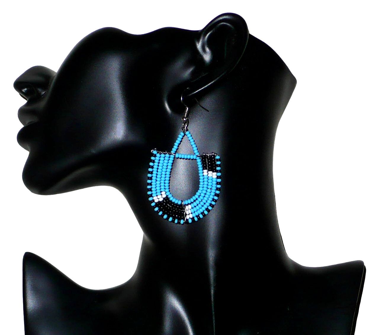 Boucles d'oreilles ethniques tricolores en forme d'ancres composées de perles bleues, noires et blanches. Elles mesurent 7 cm de long et 4 cm de large et se portent sur des oreilles percées.