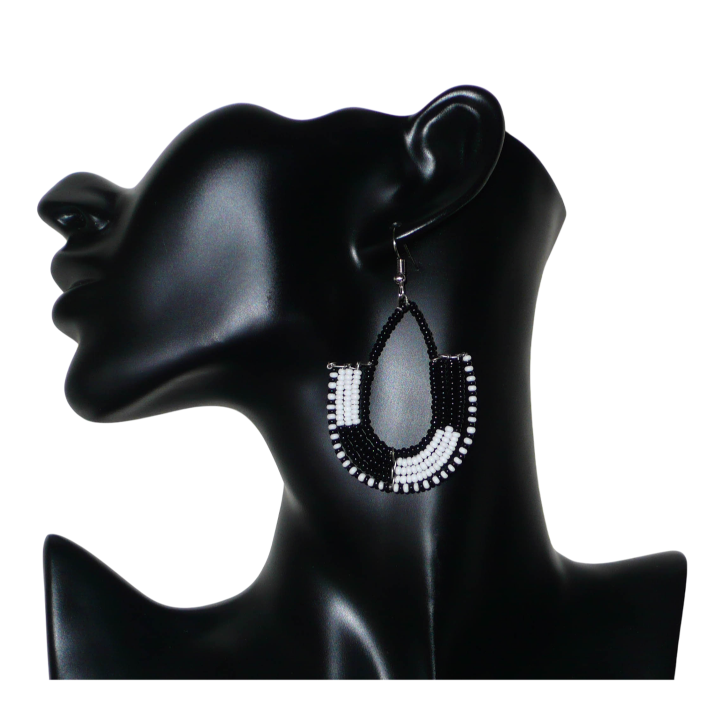 Boucles d'oreilles ethniques bicolores en forme d'ancres composées de perles de rocaille noires et blanches glissées sur des structures géométriques en fils de fer. De taille moyenne, ces boucles d'oreilles aux accents afro chic mesurent 7 cm de long et 4 cm de large ; elles se portent avec des crochets en acier inoxydable sur des oreilles percées.
