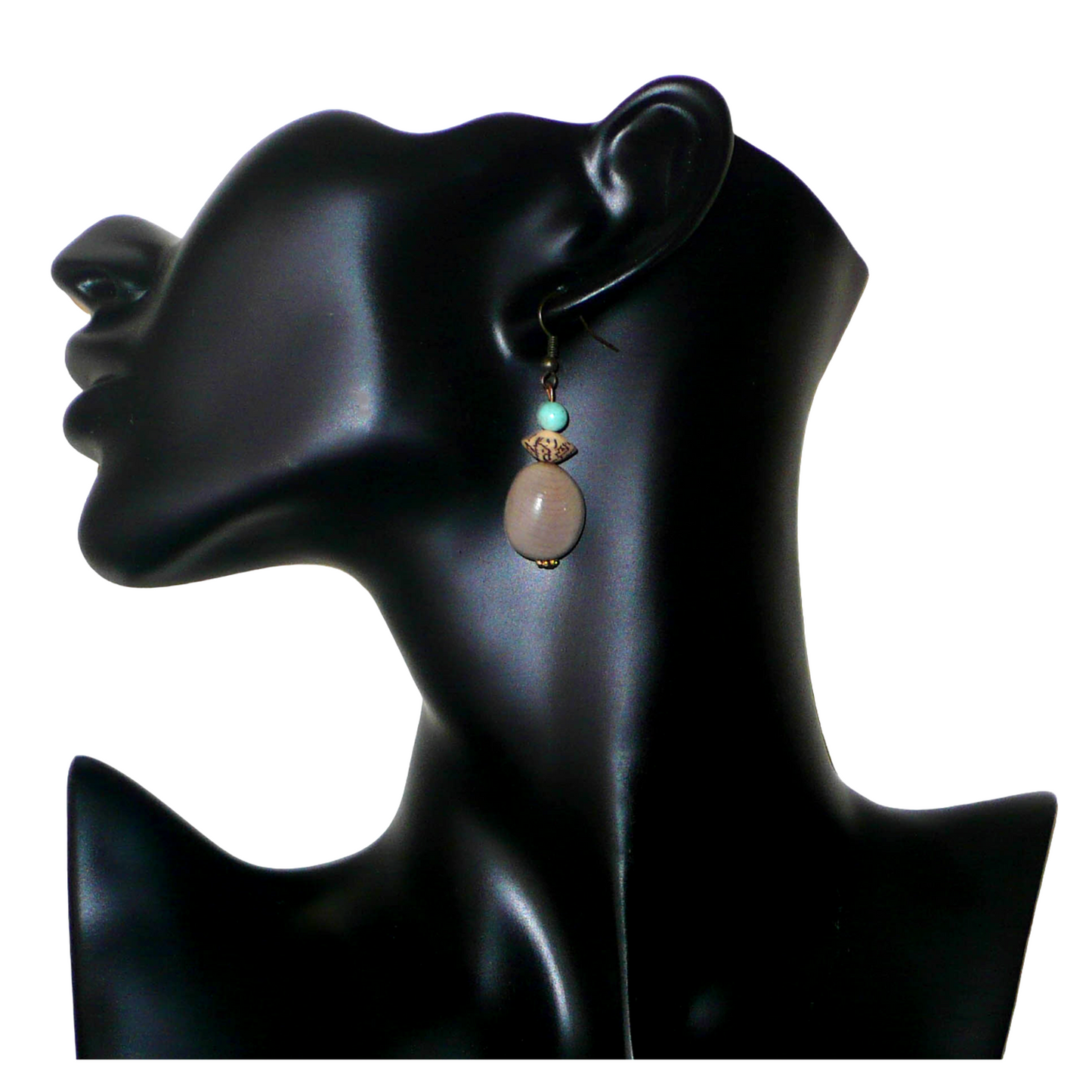 Boucles d'oreilles exotiques composées de perles et de graines de caniques grises. De taille moyenne, elles mesurent 5 cm de long et 1,5 cm de large, et se portent sur des oreilles percées.