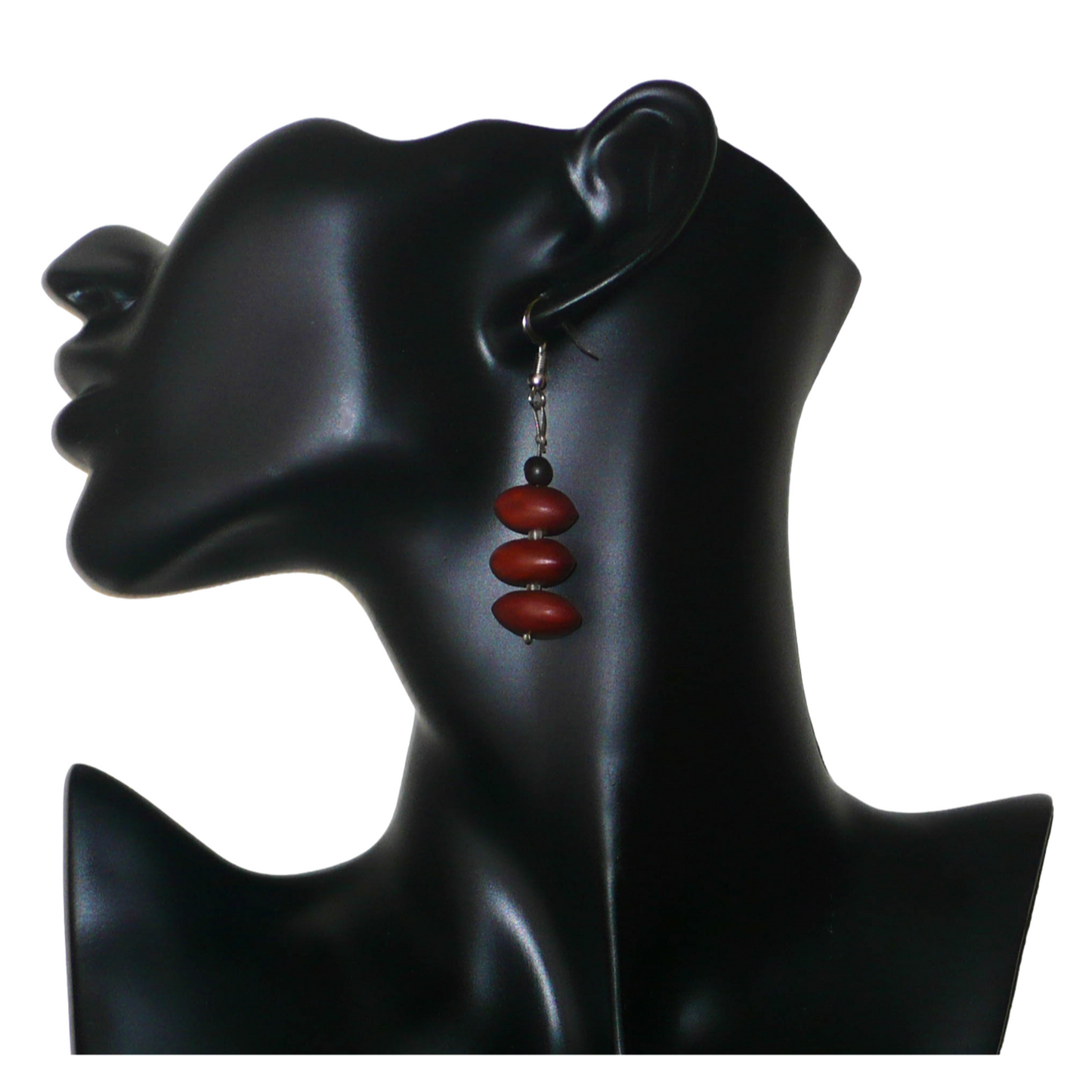 Boucles d'oreilles afro-caribéennes composées de graines organiques issues de la forêt tropicale et de perles de rocailles translucides. De taille moyenne, elles mesurent 6 cm de long et 2 cm de large, et se portent avec des crochets en acier inoxydable sur des oreilles percées.
