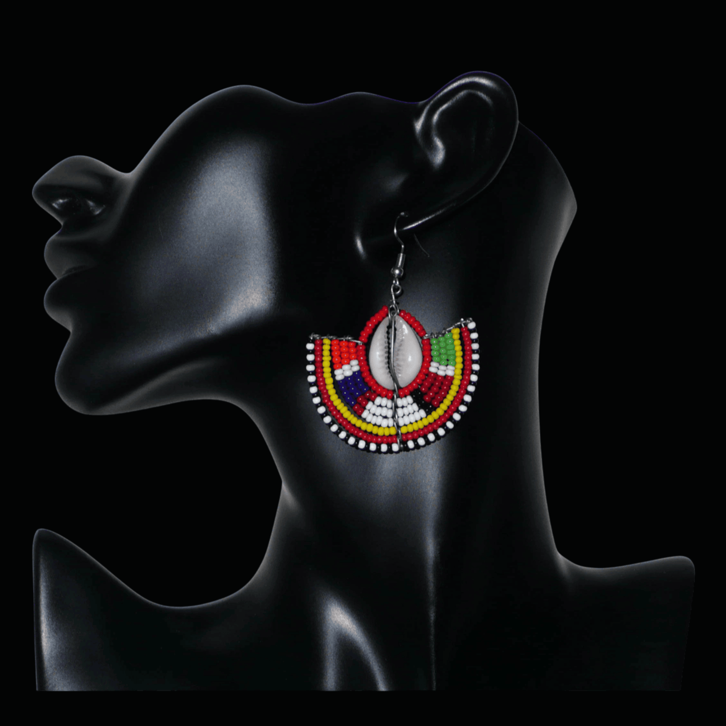 Ajoutez une touche exotique à votre style avec cette jolie paire de boucles d'oreilles africaines issues de l'artisanat traditionnel Massai. Ces boucles d'oreilles ethniques chic se composent de perles de rocaille rouges et multicolores et de coquillages cauris. De taille moyenne, elles mesurent 6 cm de long et 4.5 cm de large, et se portent avec des crochets en acier inoxydable sur des oreilles percées.