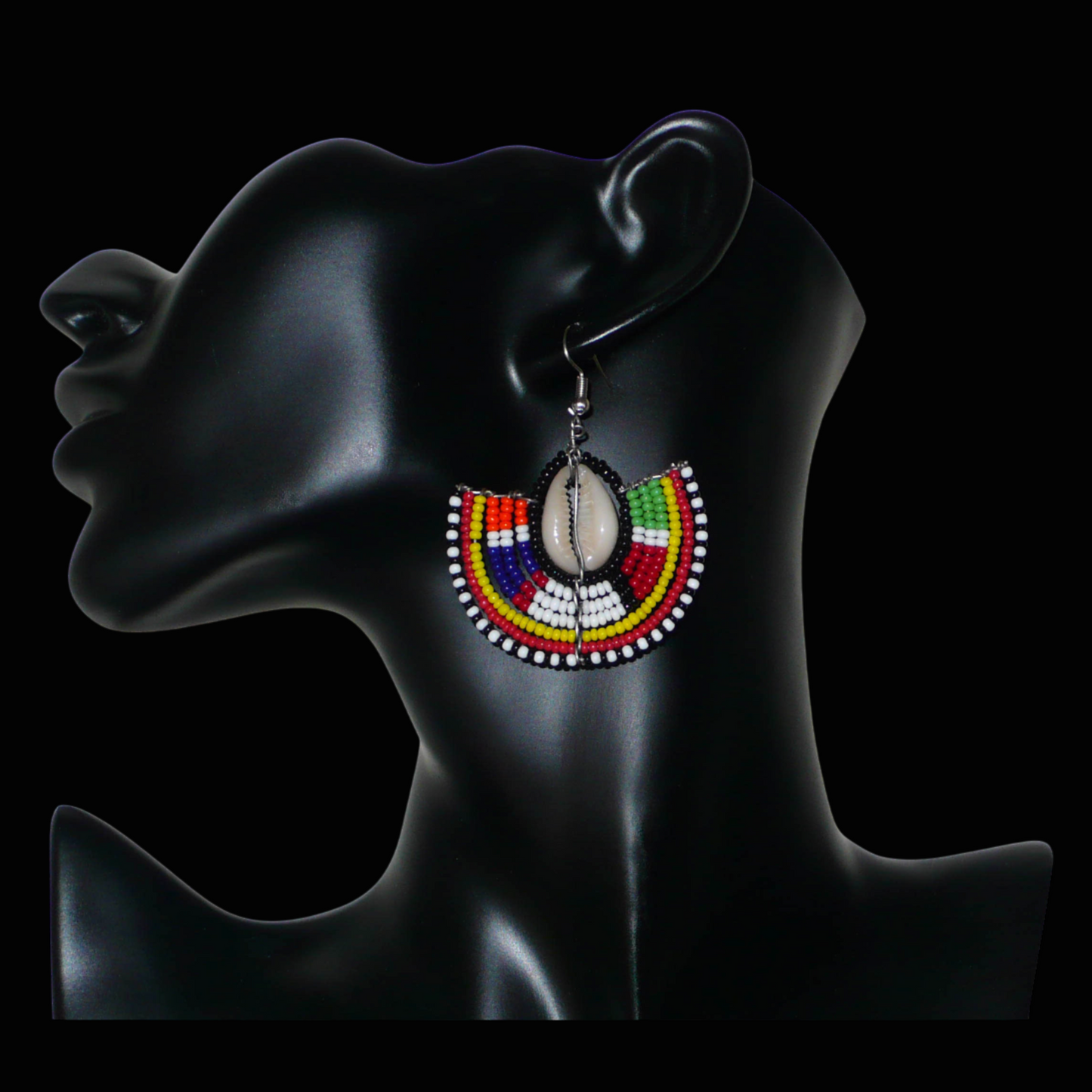 Apportez une note de couleurs à votre look avec cette paire de boucles d'oreilles africaines au style exotique chic issues de l'artisanat traditionnel Massai. Confectionnées à la main au Kenya, ces boucles d'oreilles se composent de perles de rocaille noires et multicolores et de coquillages cauris. De taille moyenne, elles mesurent 6 cm de long et 4.5 cm de large, et se portent avec des crochets en acier inoxydable sur des oreilles percées.