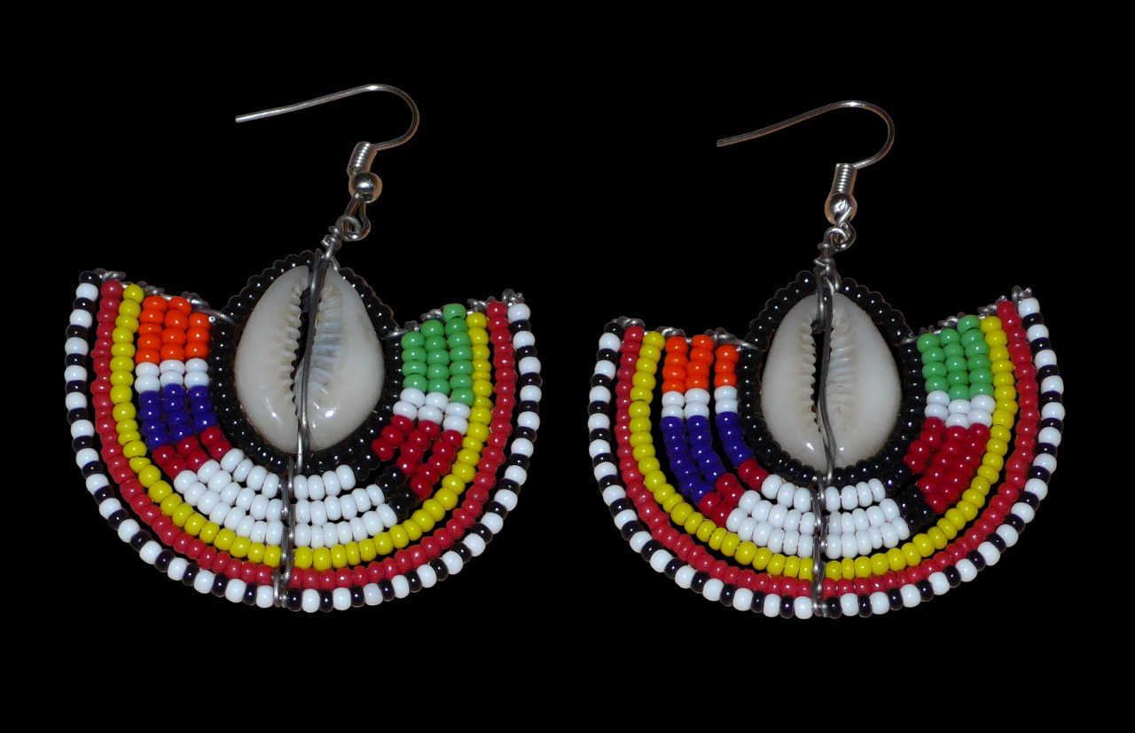 Apportez une note de couleurs à votre look avec cette paire de boucles d'oreilles africaines au style exotique chic issues de l'artisanat traditionnel Massai. Confectionnées à la main au Kenya, ces boucles d'oreilles se composent de perles de rocaille noires et multicolores et de coquillages cauris. De taille moyenne, elles mesurent 6 cm de long et 4.5 cm de large, et se portent avec des crochets en acier inoxydable sur des oreilles percées.
