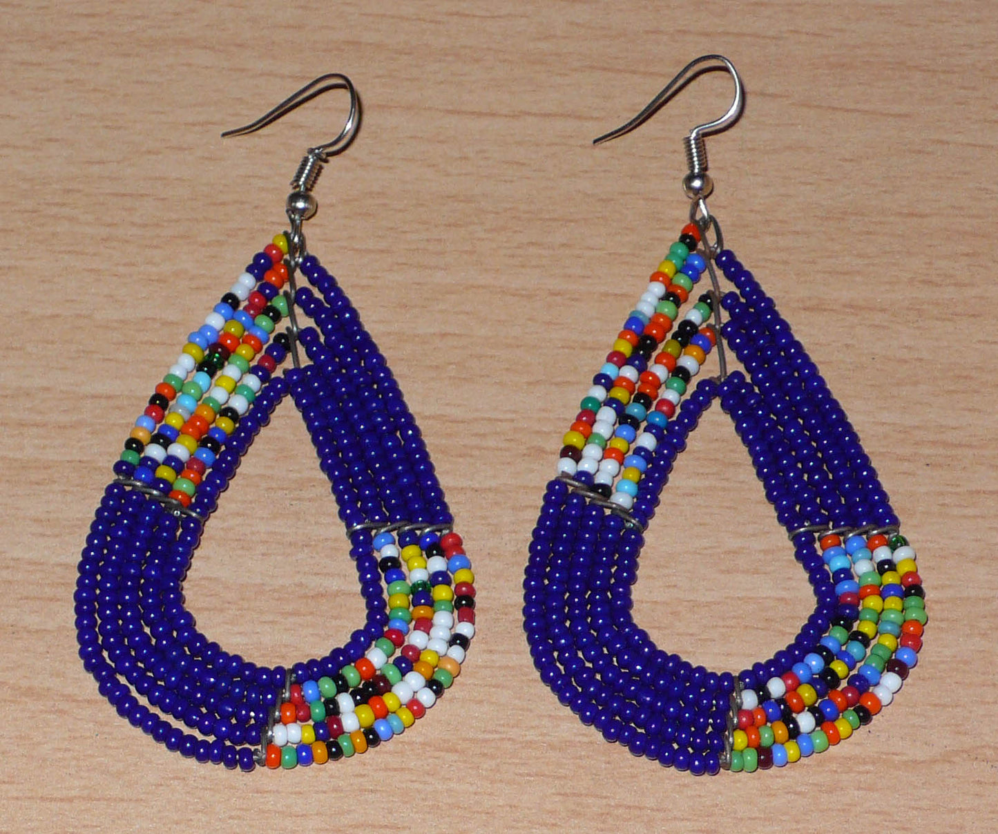 afro boho chic des années 70. Elles se composent de perles de rocaille bleu foncé et d'un mélange de perles multicolores glissées sur cinq rangées de fils de fer en forme de gouttes légèrement triangulaires. Ces boucles d'oreilles mesurent 8 cm de long et 4 cm de large ; elles se portent avec des crochets en acier inoxydable sur des oreilles percées.