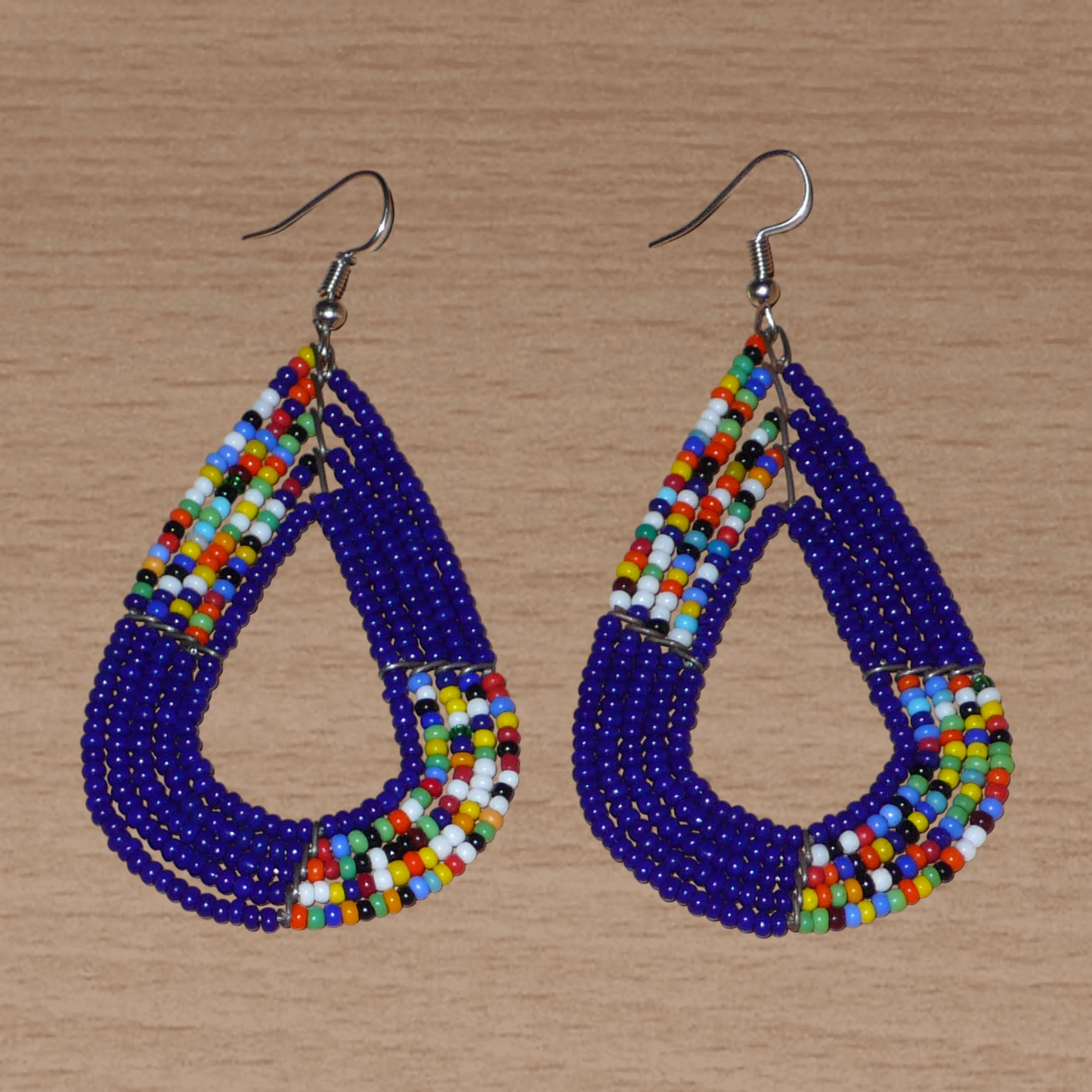 afro boho chic des années 70. Elles se composent de perles de rocaille bleu foncé et d'un mélange de perles multicolores glissées sur cinq rangées de fils de fer en forme de gouttes légèrement triangulaires. Ces boucles d'oreilles mesurent 8 cm de long et 4 cm de large ; elles se portent avec des crochets en acier inoxydable sur des oreilles percées.