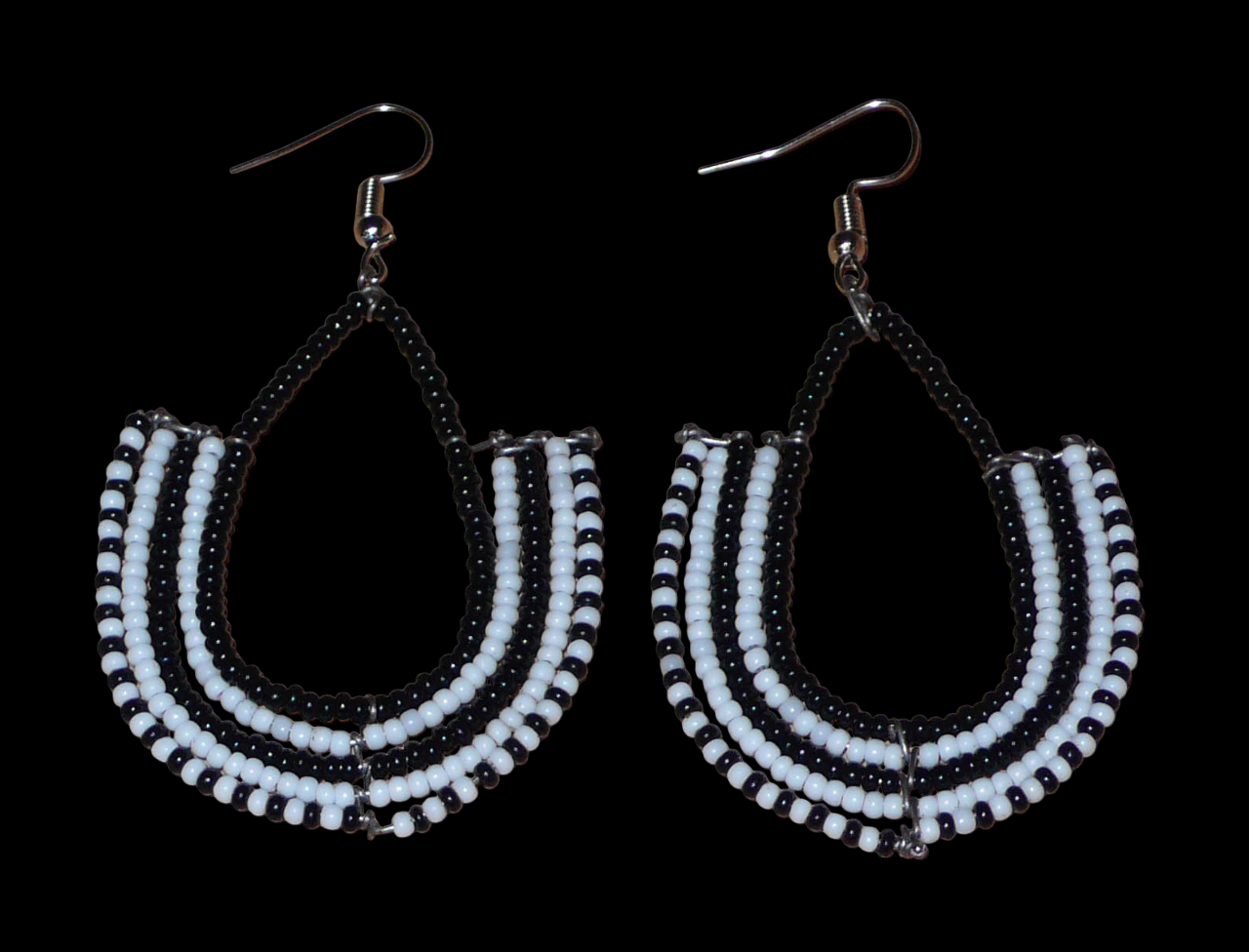 Boucles d'oreilles kenyanes Massai bicolores en forme d'ancres composées de perles de rocaille noires et blanches glissées sur des structures géométriques en fils de fer. De taille moyenne, ces boucles d'oreilles aux accents ethniques afro chic mesurent 7 cm de long et 4 cm de large ; elles se portent avec des crochets en acier inoxydable sur des oreilles percées.