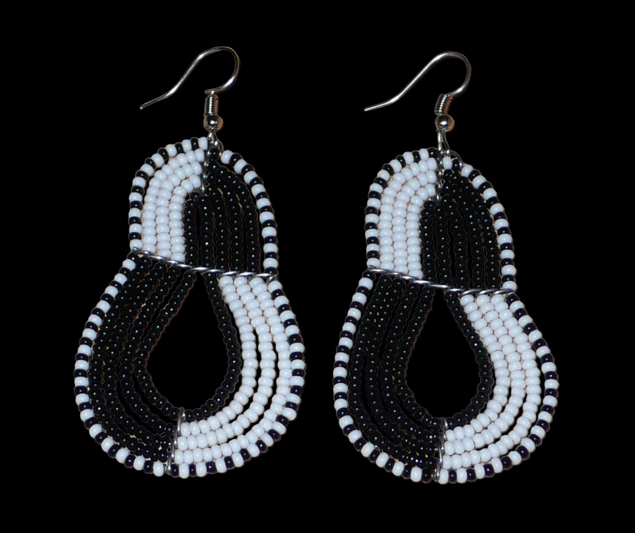 Boucles d'oreilles bicolores composées de perles noires et blanches montées en forme de poires. Elles mesurent 8 cm de long et 3,8 cm de large et se portent sur des oreilles percées.
