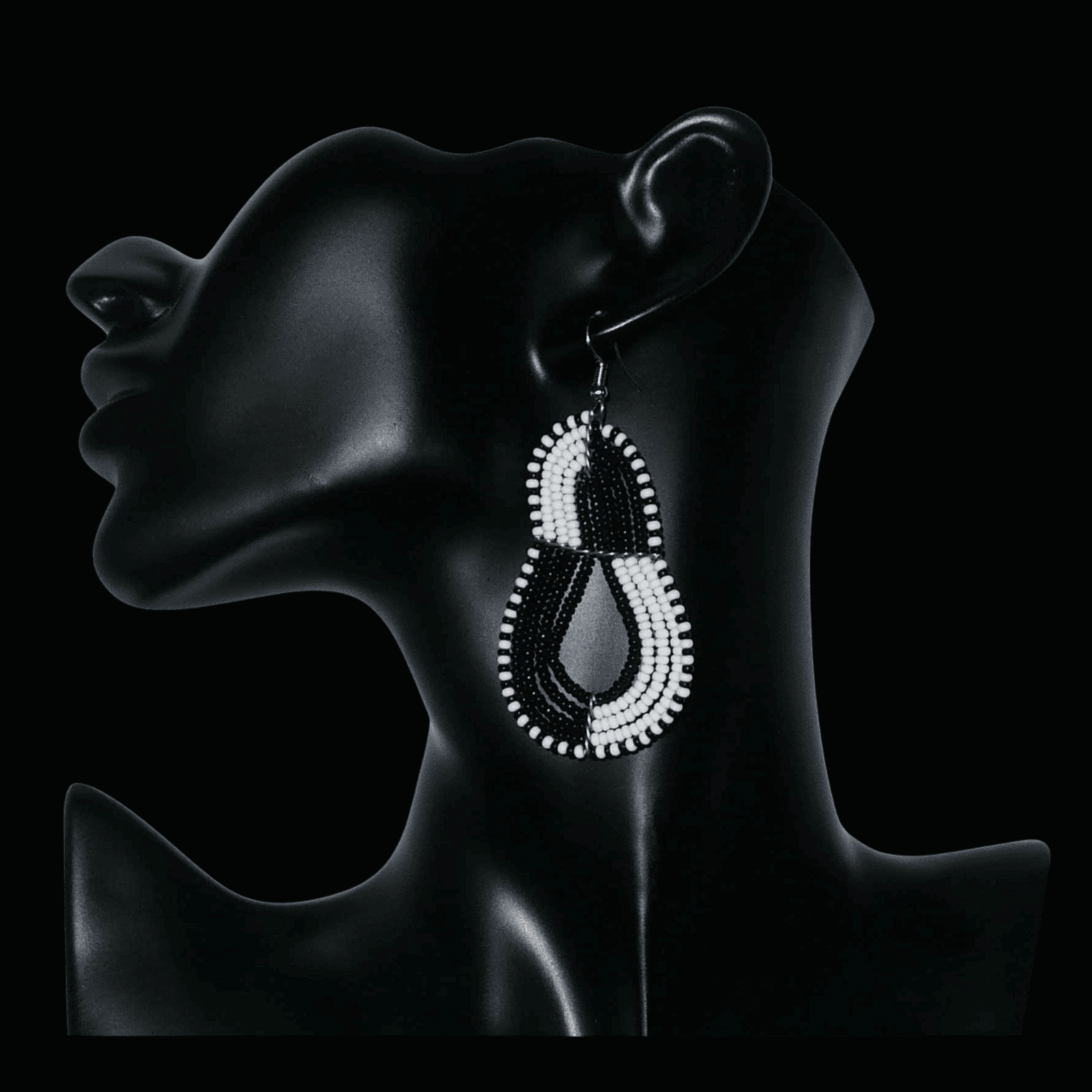 Boucles d'oreilles bicolores composées de perles noires et blanches montées en forme de poires. Elles mesurent 8 cm de long et 3,8 cm de large et se portent sur des oreilles percées.