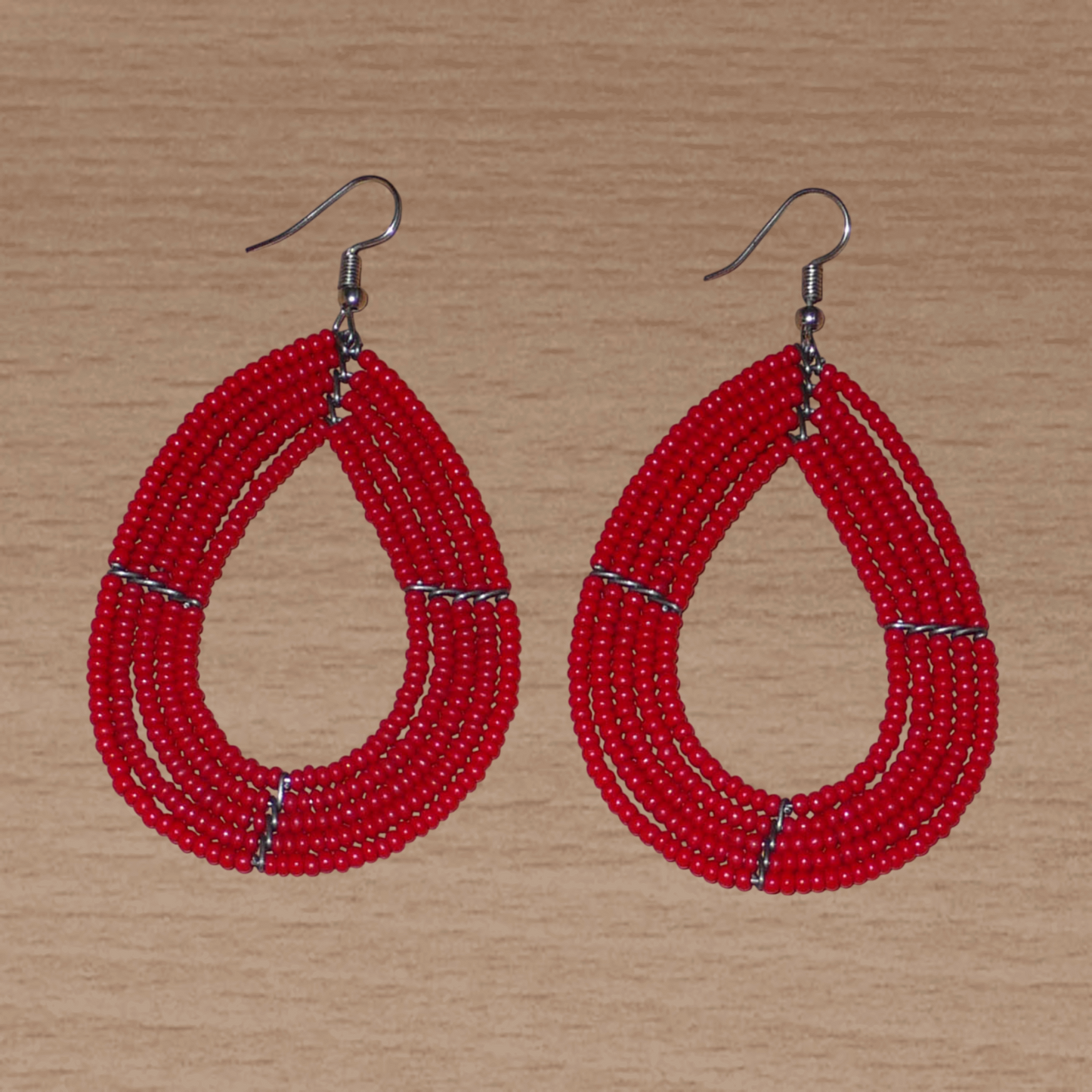 Boucles d'oreilles multi-rangs en forme de gouttes composées de perles de rocaille rouges.