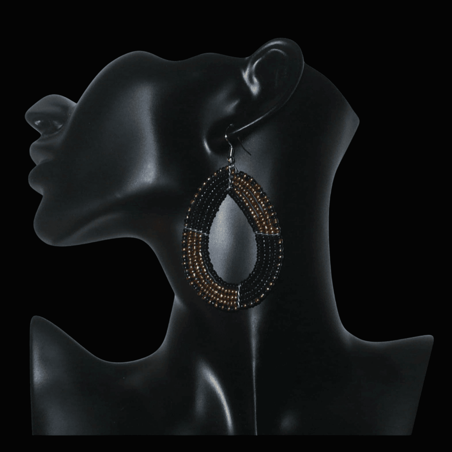 Boucles d'oreilles multi-rangs en perles de rocaille noires et dorées montées en forme de gouttes ; elles mesurent 8 cm de long et 4,5 cm de large, et se portent avec des crochets sur des oreilles percées.