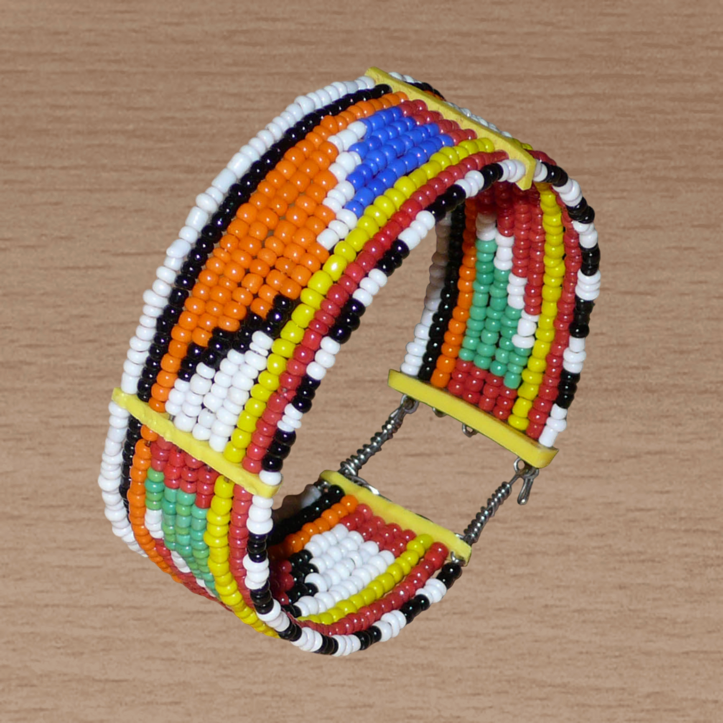 Bracelet africain Massai traditionnel composé de dix rangées de perles de rocaille multicolores enfilées sur des fils de fer fixés sur des charnières en plastique ; il se ferme avec deux crochets.