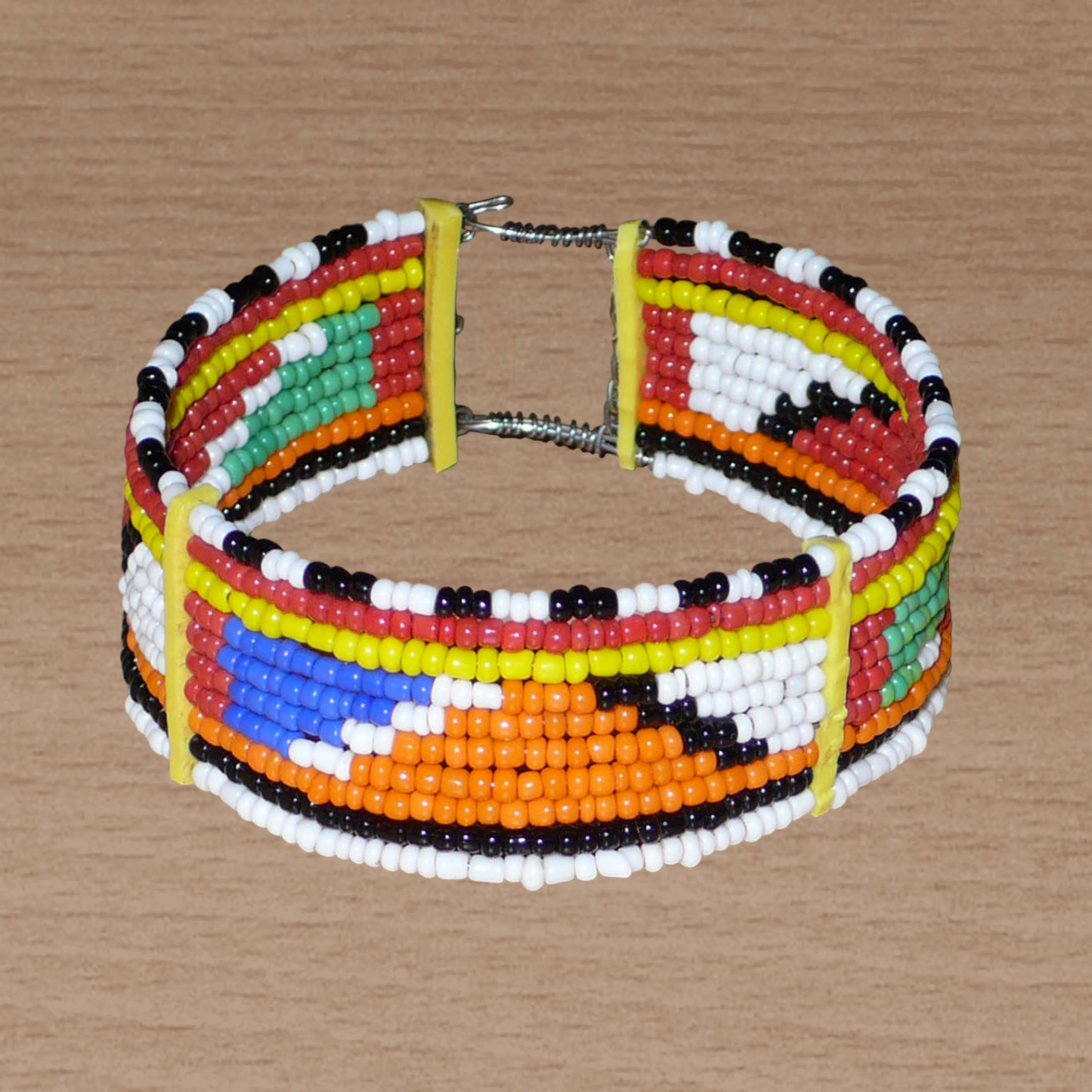 Bracelet africain Massai traditionnel composé de dix rangées de perles de rocaille multicolores enfilées sur des fils de fer fixés sur des charnières en plastique ; il se ferme avec deux crochets.