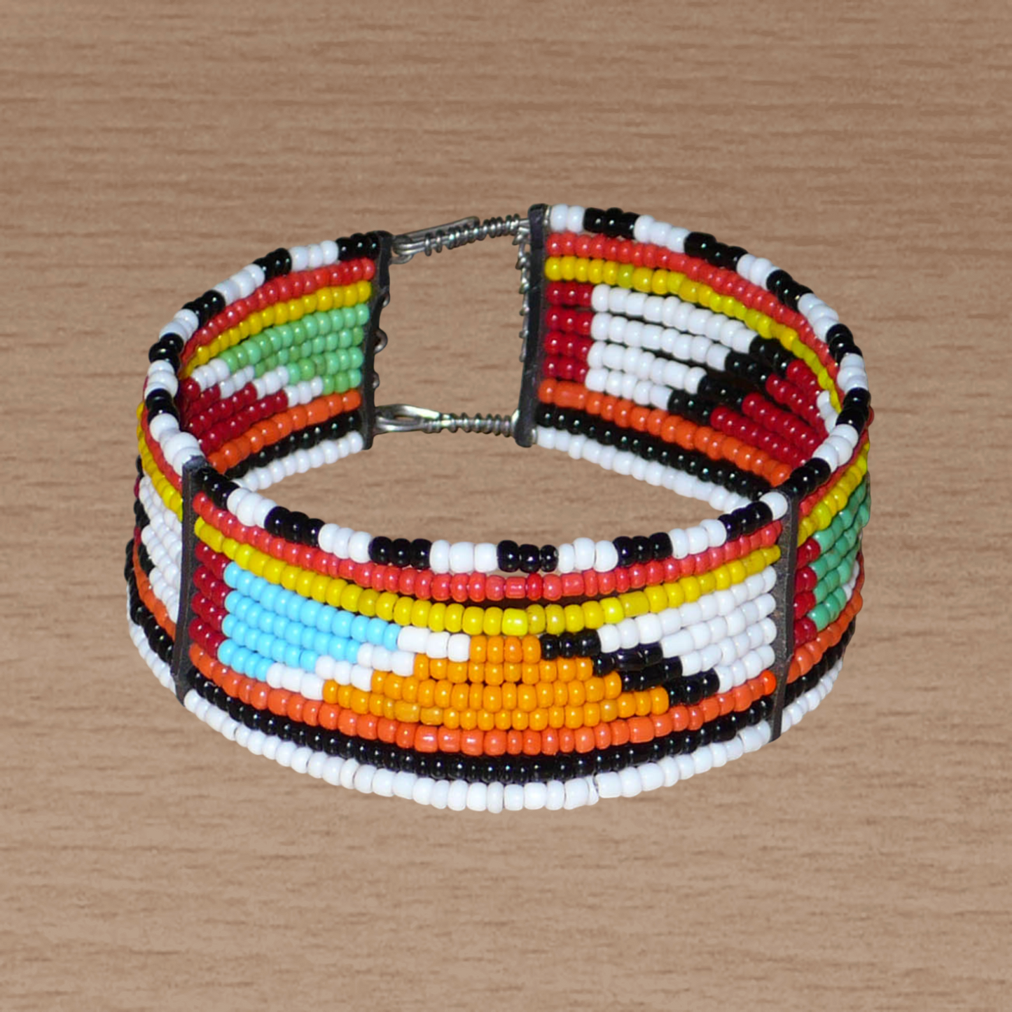 Bracelet africain tribal à motifs géométriques Massai fait de dix rangées de perles de rocaille multicolores enfilées sur des fils de fer fixés sur des charnières en plastique. Le bracelet se ferme avec des crochets.