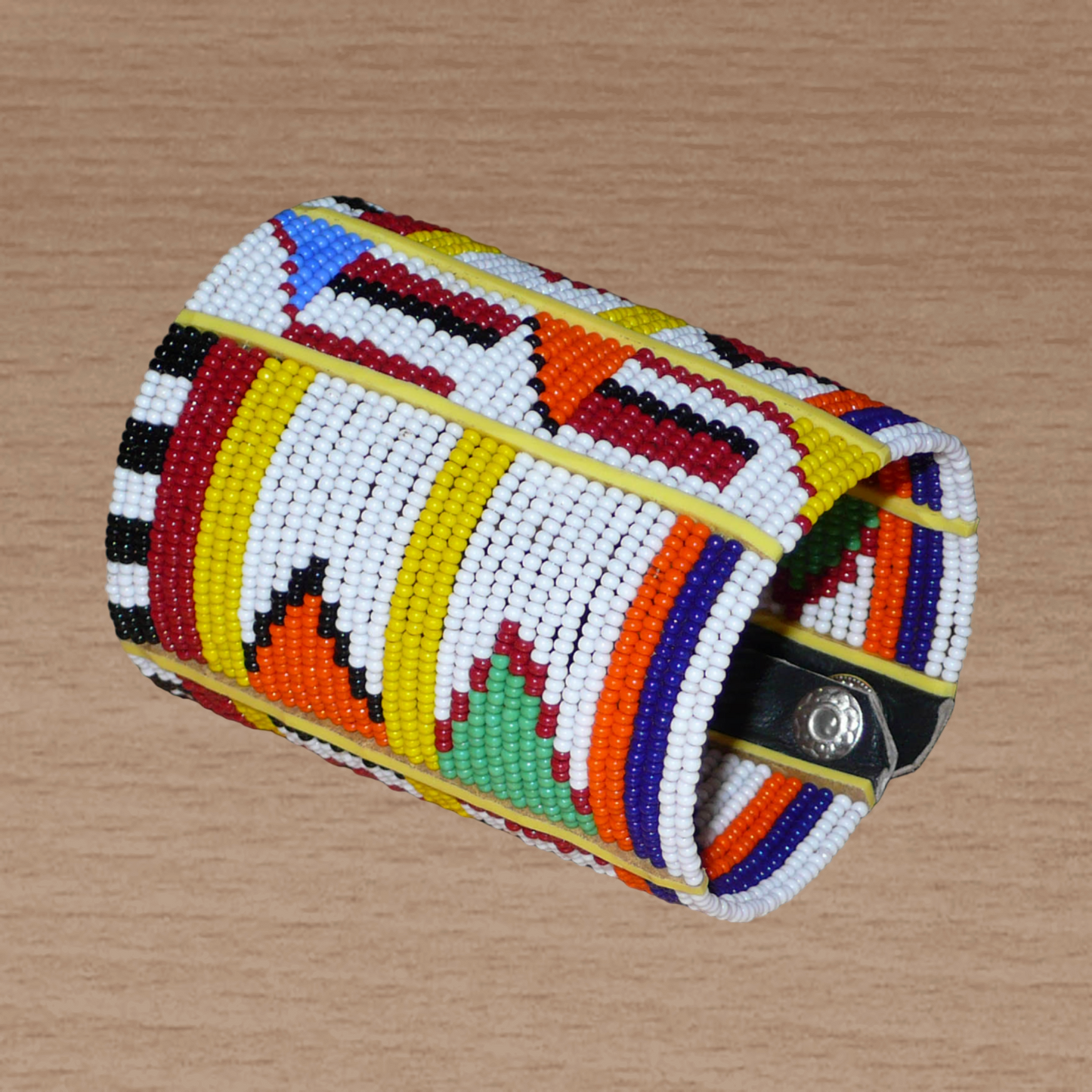 Bracelet africain Massai multi-rangs à motifs ethniques composé de trente-six rangées de perles de rocaille blanches et multicolores glissées sur des fils de fer fixés sur des charnières en plastique jaune.