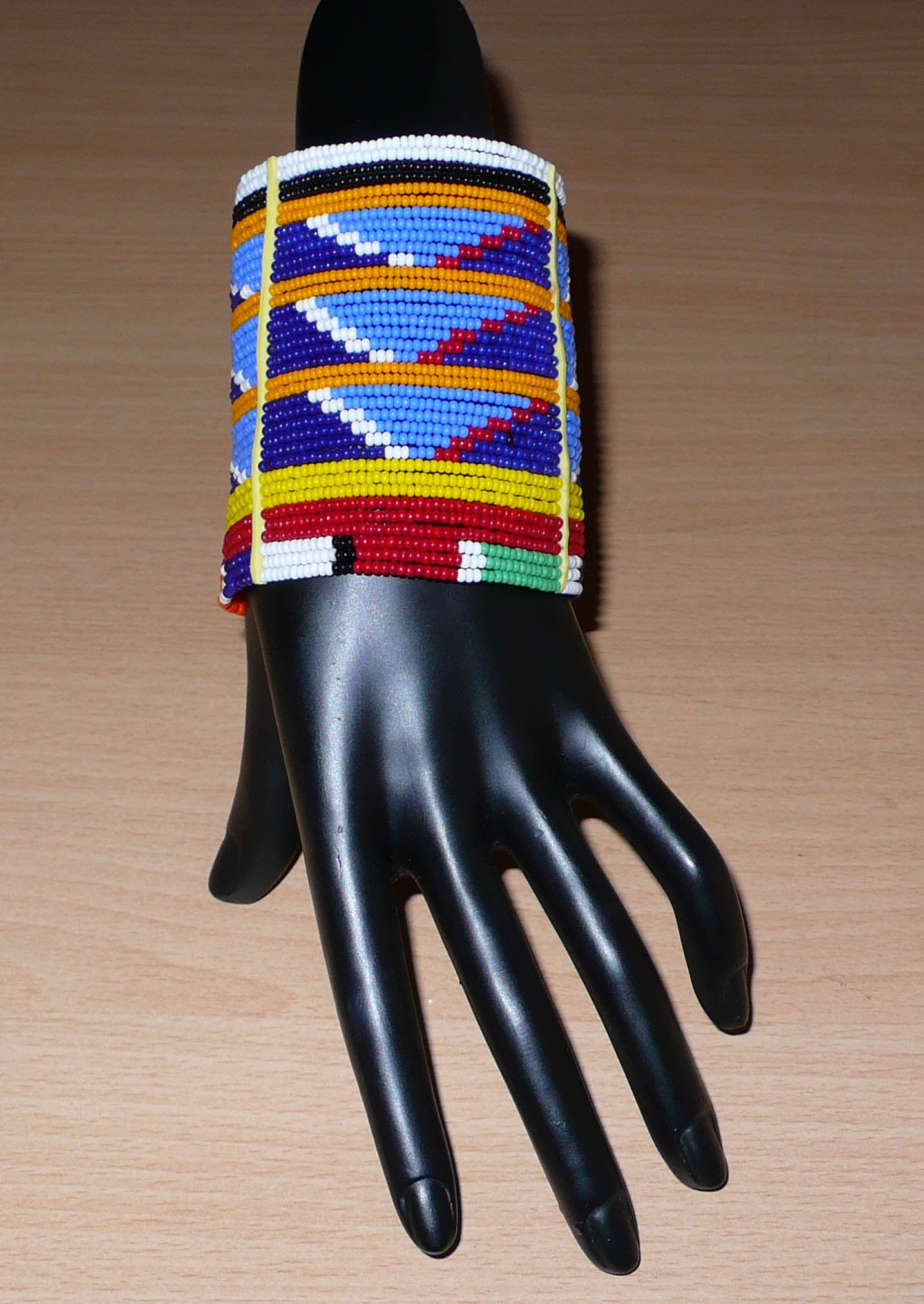 Bracelet africain Massai bleu et multicolore à motifs ethniques traditionnels composé de trente-six rangées de perles de rocaille tissées.
