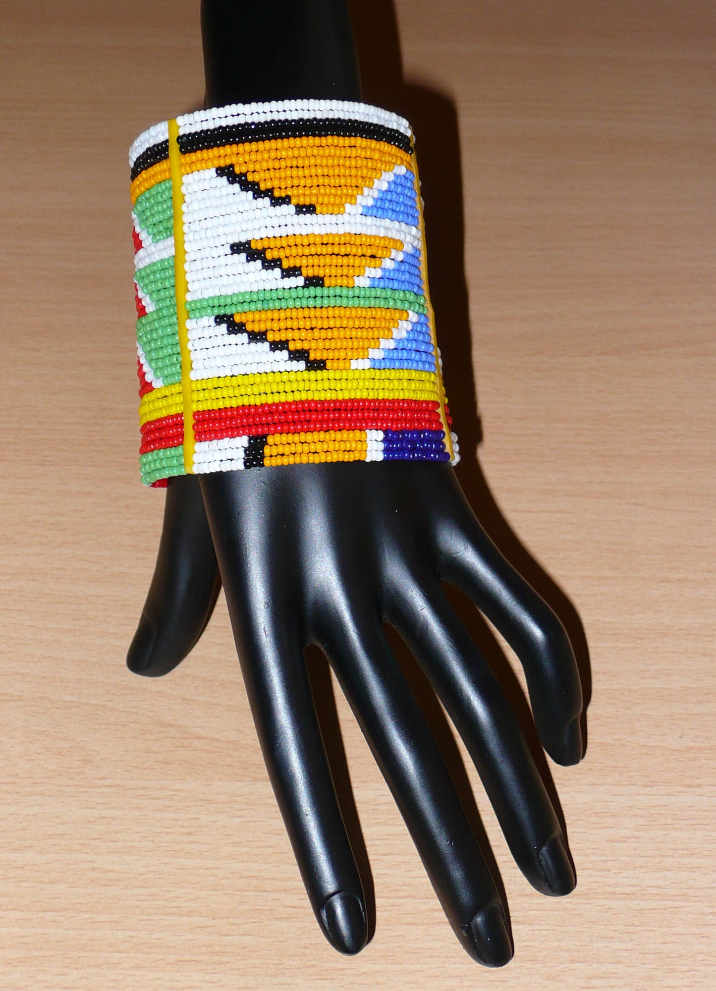 Bracelet africain tribal à motifs ethniques et géométriques Massai composé de perles de rocaille multicolores. Il s'attache avec trois boutons pressions.