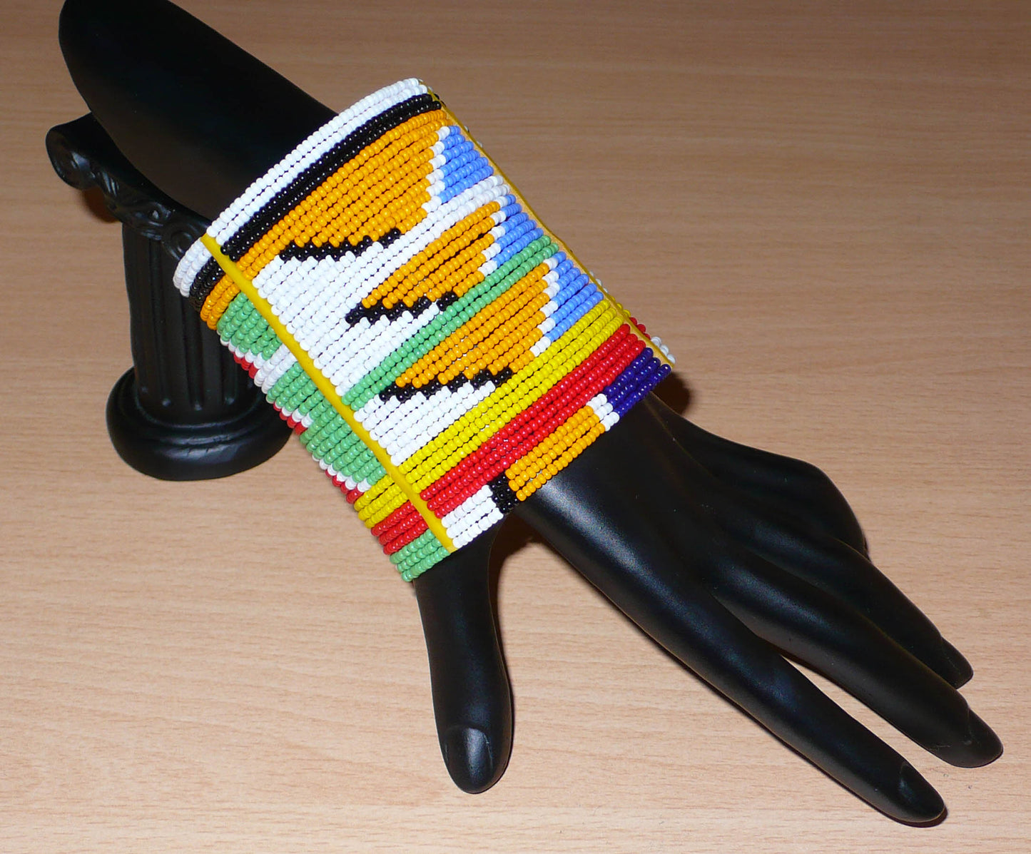 Bracelet africain tribal à motifs ethniques et géométriques Massai composé de perles de rocaille multicolores. Il s'attache avec trois boutons pressions.