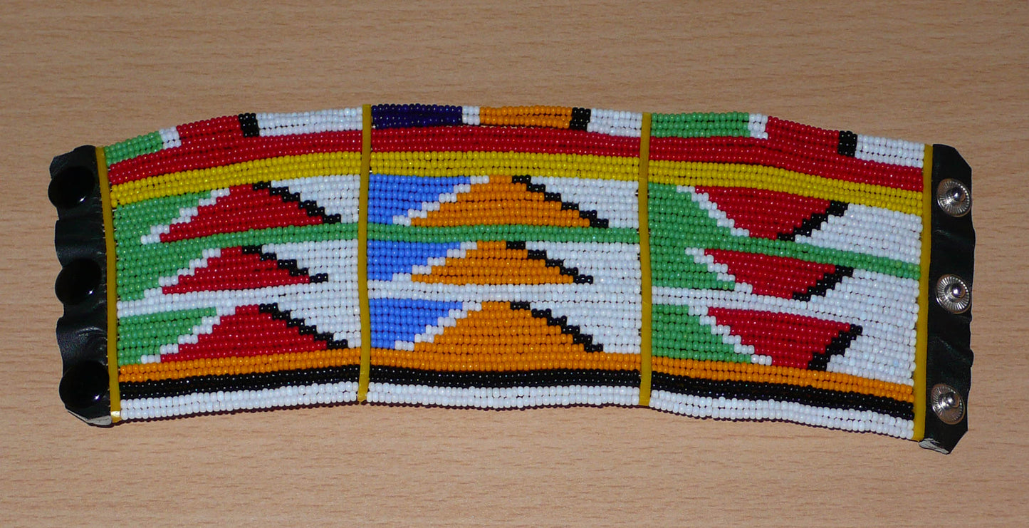 Bracelet africain tribal à motifs ethniques et géométriques Massai composé de perles de rocaille multicolores. Il s'attache avec trois boutons pressions.