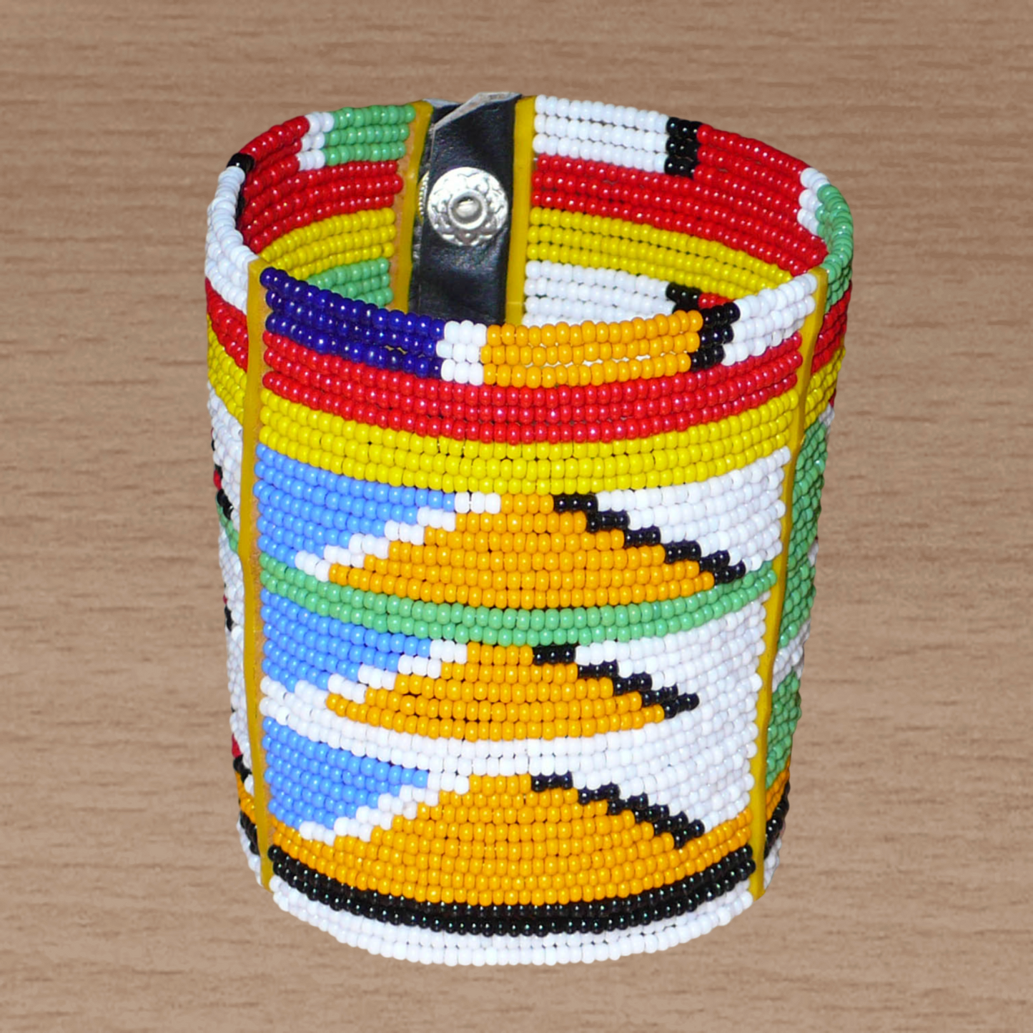 Bracelet africain tribal à motifs ethniques et géométriques Massai composé de perles de rocaille multicolores. Il s'attache avec trois boutons pressions.
