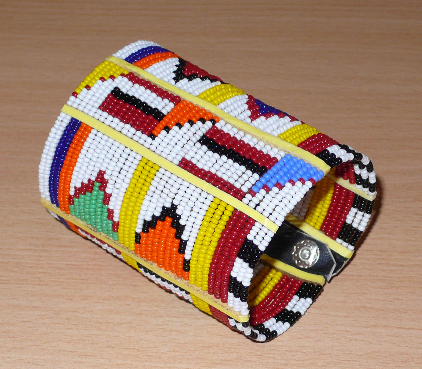 Bracelet africain traditionnel multi-rangs aux couleurs vives et motifs géométriques Massai composé de trente-six rangées de perles de rocaille blanches et multicolores.