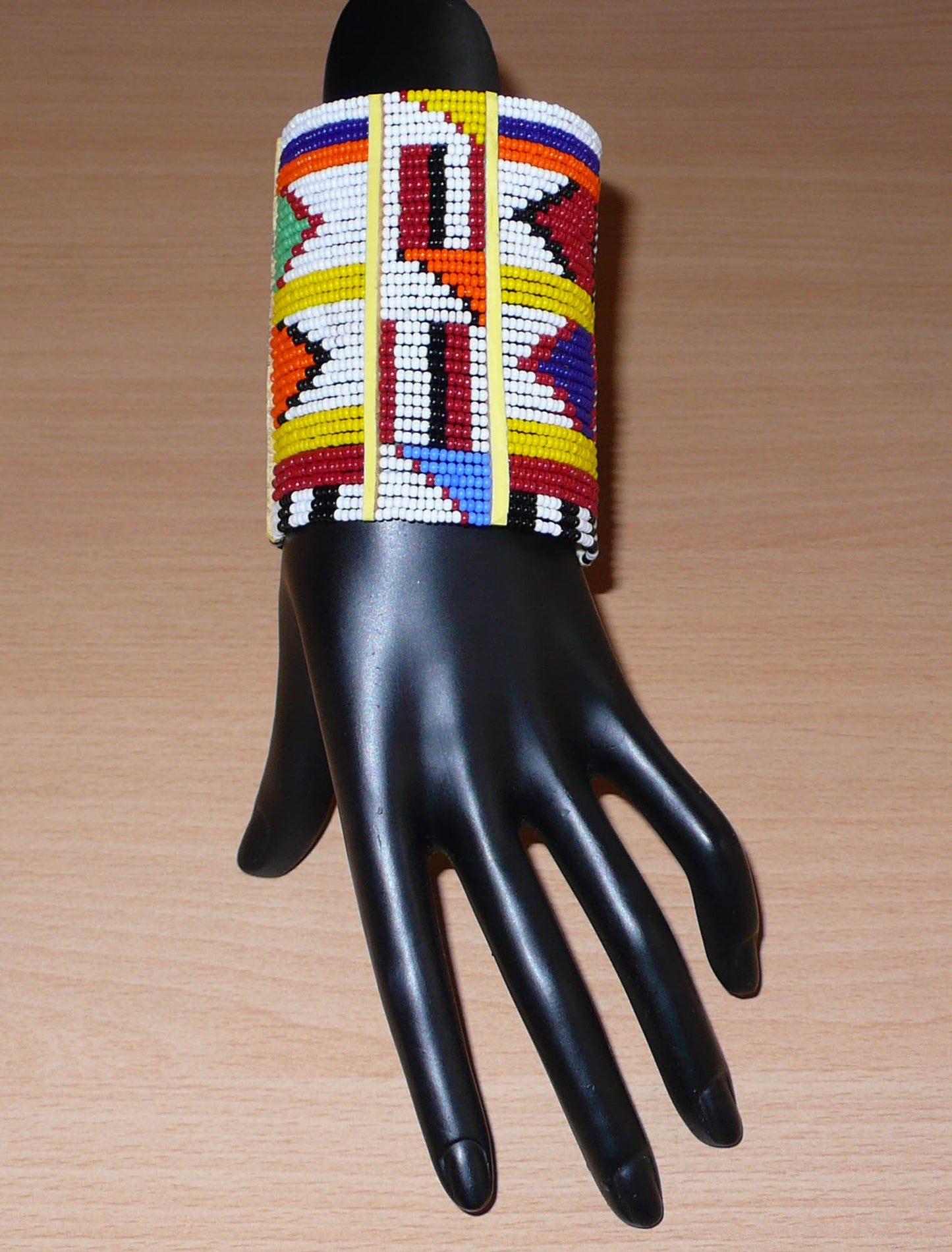 Bracelet africain traditionnel multi-rangs aux couleurs vives et motifs géométriques Massai composé de trente-six rangées de perles de rocaille blanches et multicolores.