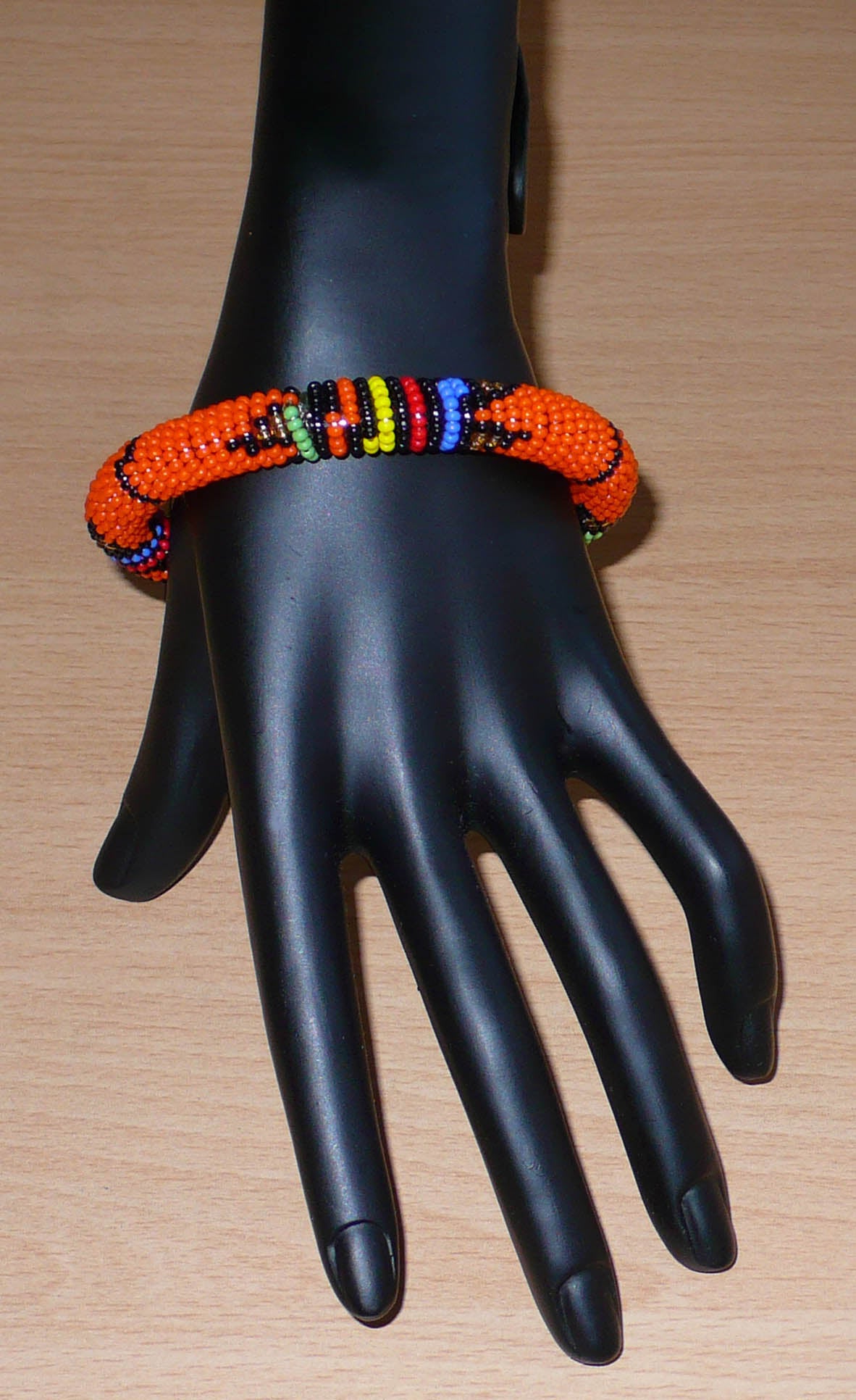 Bracelet africain traditionnel orange et multicolore à motifs ethniques zoulous composé de perles de rocaille tissées.