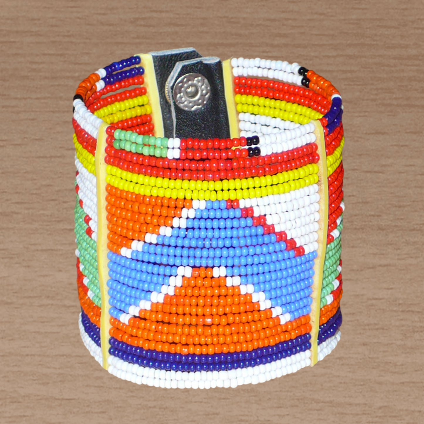 Bracelet africain traditionnel composé de vingt-six rangées de perles multicolores aux couleurs et motifs Massai enfilées sur des fils de fer fixés sur des charnières en plastique. Le bracelet se ferme avec des boutons pressions.
