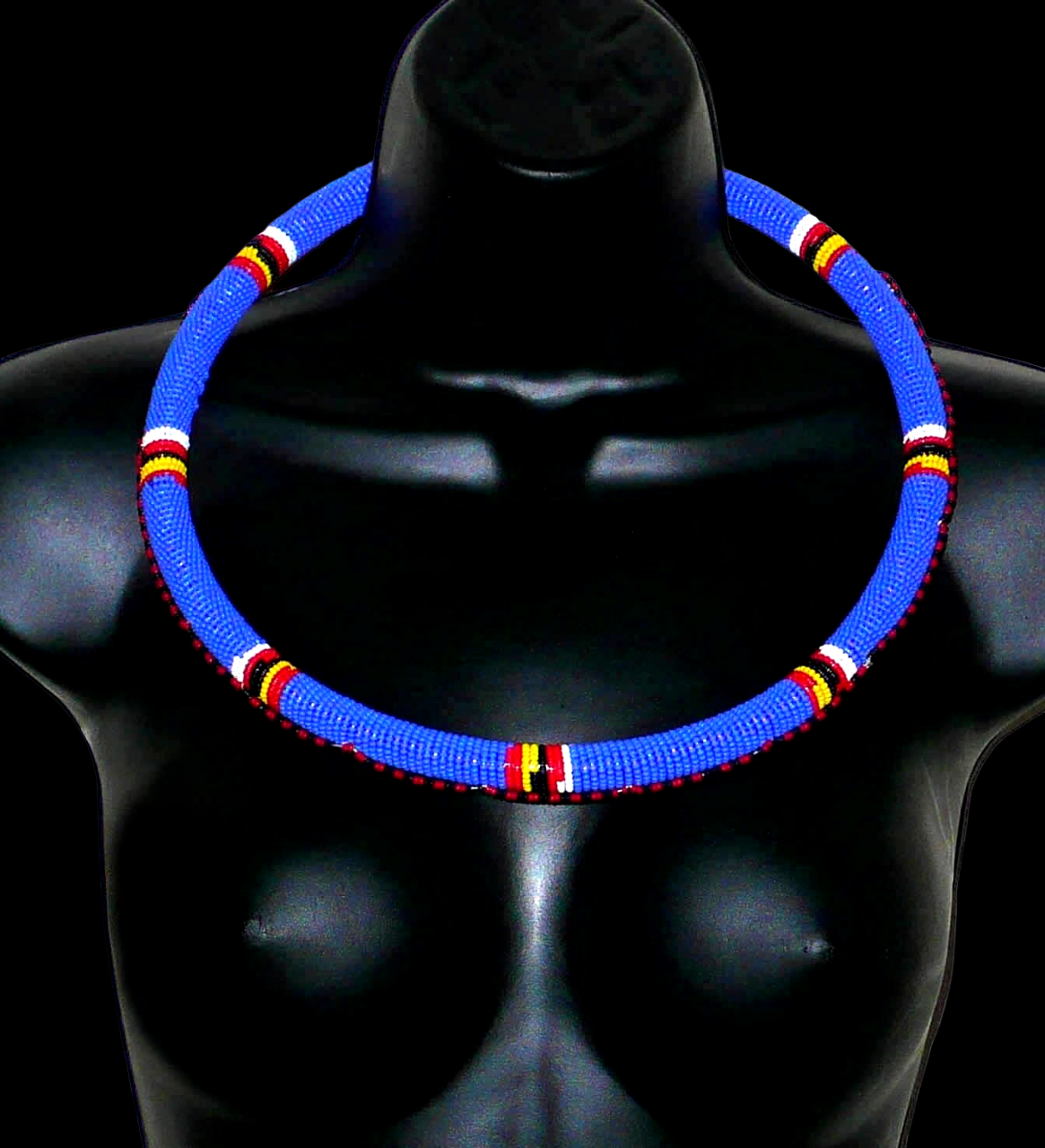 Collier africain Massai tubulaire composé de perles de rocaille principalement bleues, décoré de motifs ethniques perlés.