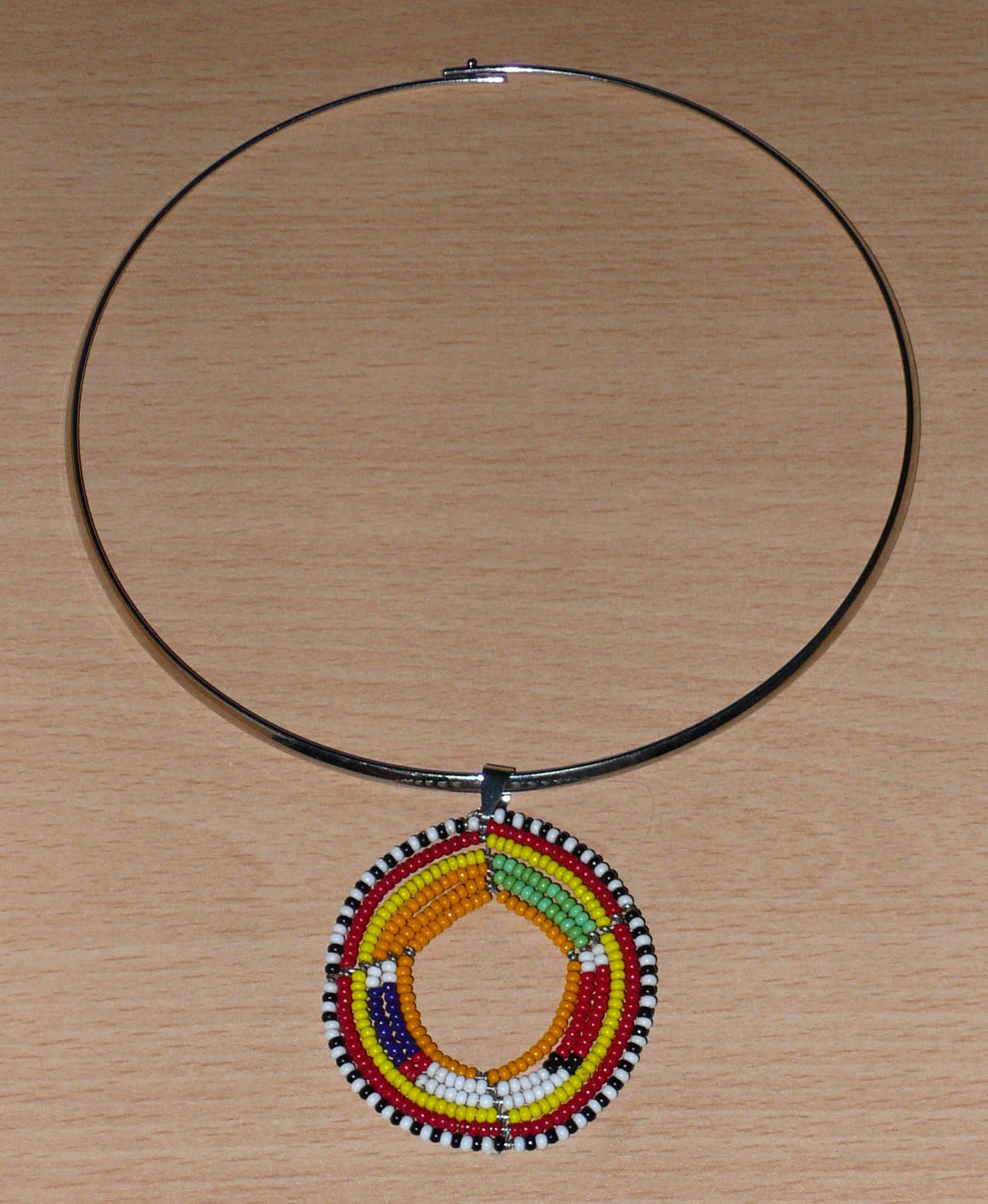 Collier africain en laiton orné d'un médaillon à motifs ethniques Massai fait de perles de rocaille orange et multicolores.
