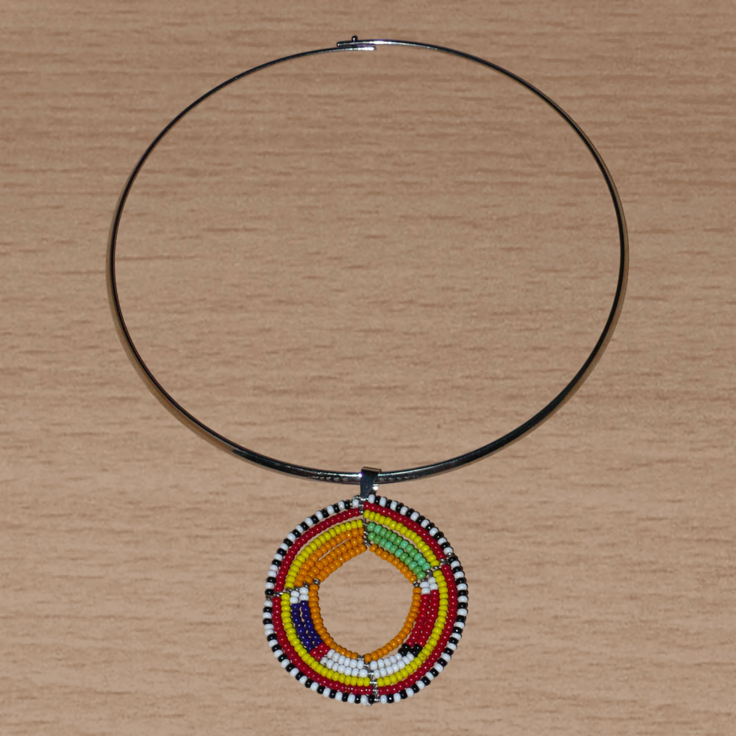 Collier africain en laiton orné d'un médaillon à motifs ethniques Massai fait de perles de rocaille orange et multicolores.