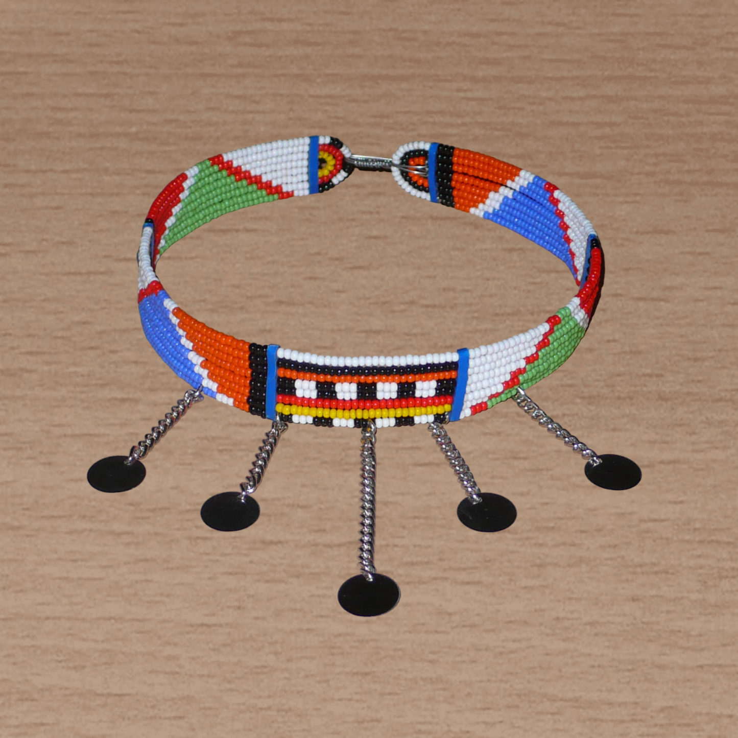 Collier africain Massai à motifs ethniques traditionnels composé de huit rangées de perles de rocaille multicolores et décoré de chaînettes ornées de disques métalliques.