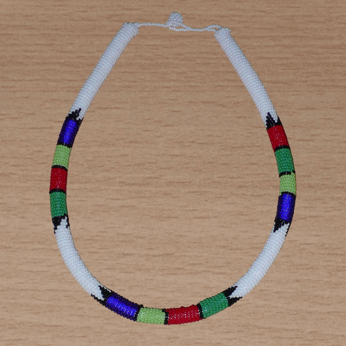Collier africain tubulaire blanc et multicolore fabriqué en Afrique du Sud composé de perles de rocaille enroulées autour d'un tube en plastique.